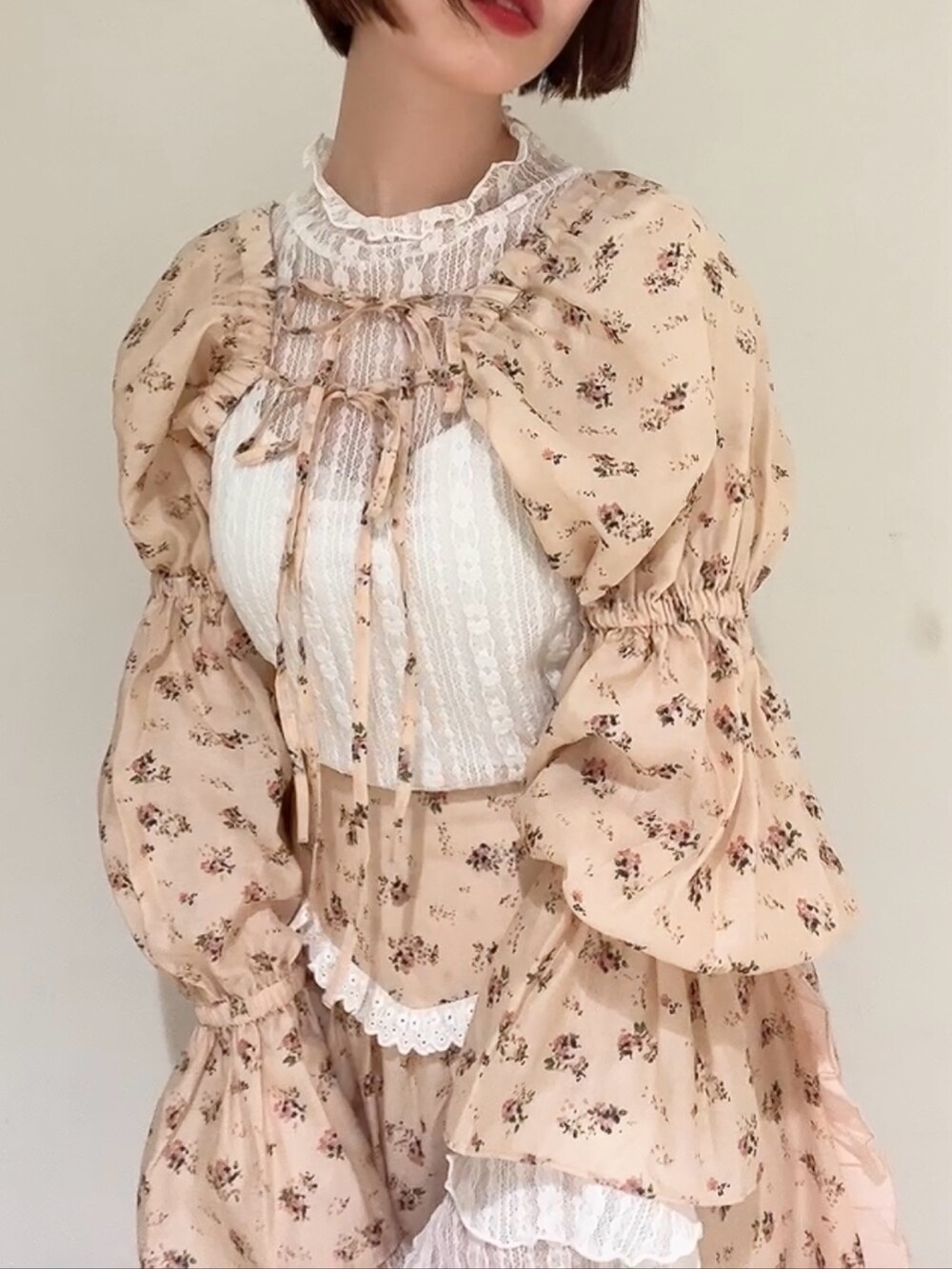 ピンク系のスカート、ピンク系のカーディガン/ボレロ、ホワイト系のパンプスを着用したレディースの春コーディネートの8枚目の写真