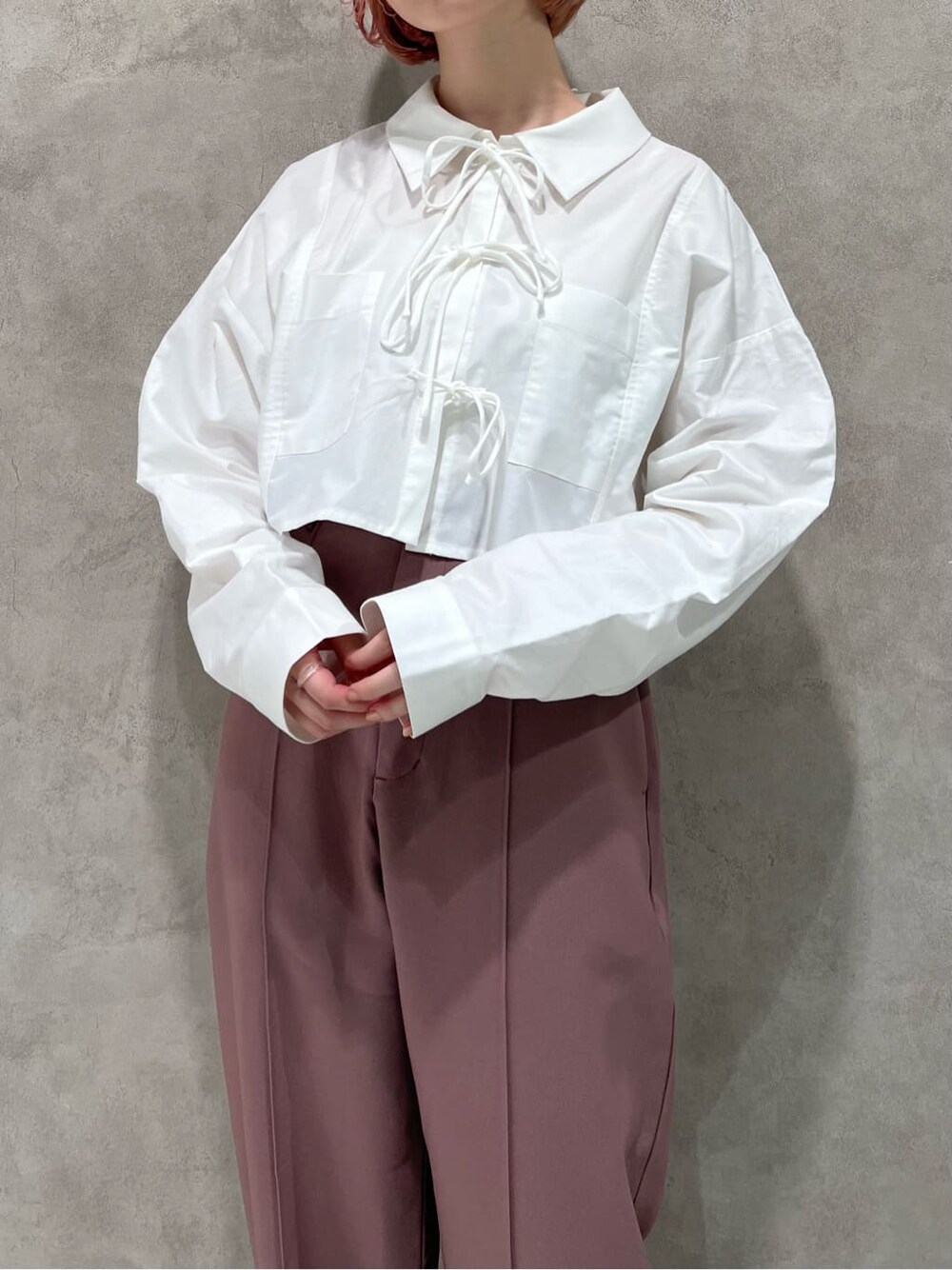 ホワイト系のシャツ/ブラウス、ピンク系のスラックス、ベージュ系のブーツを着用したレディースの秋コーディネートの8枚目の写真