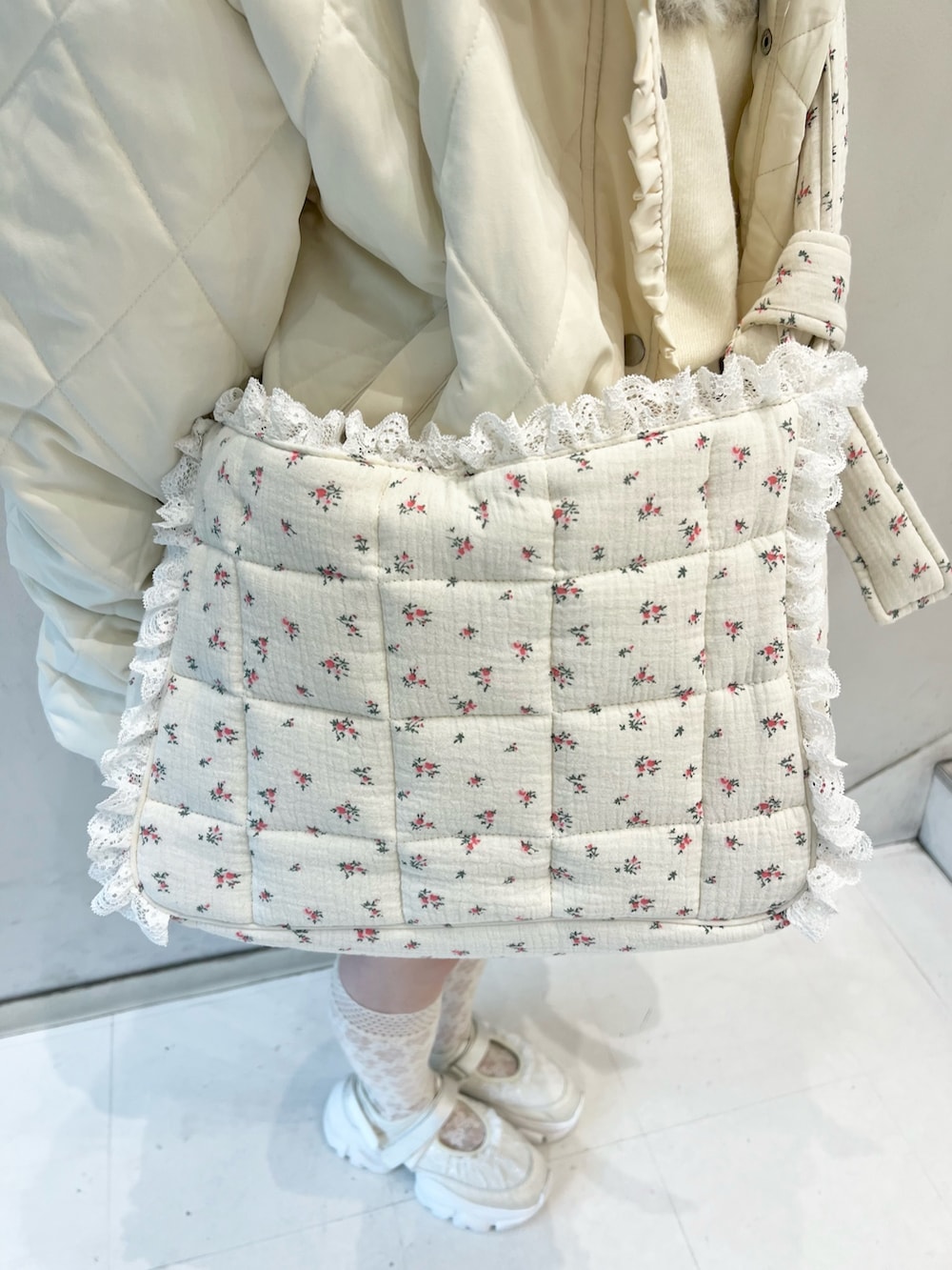ホワイト系のニット/セーター、ホワイト系のダウンジャケット/コート、ピンク系のショルダーバッグを着用したレディースの秋コーディネートの10枚目の写真