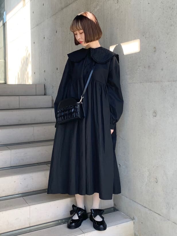 ブラック系のパンプス、ブラック系のワンピース、ブラック系のショルダーバッグを着用したレディースの冬コーディネートの2枚目の写真