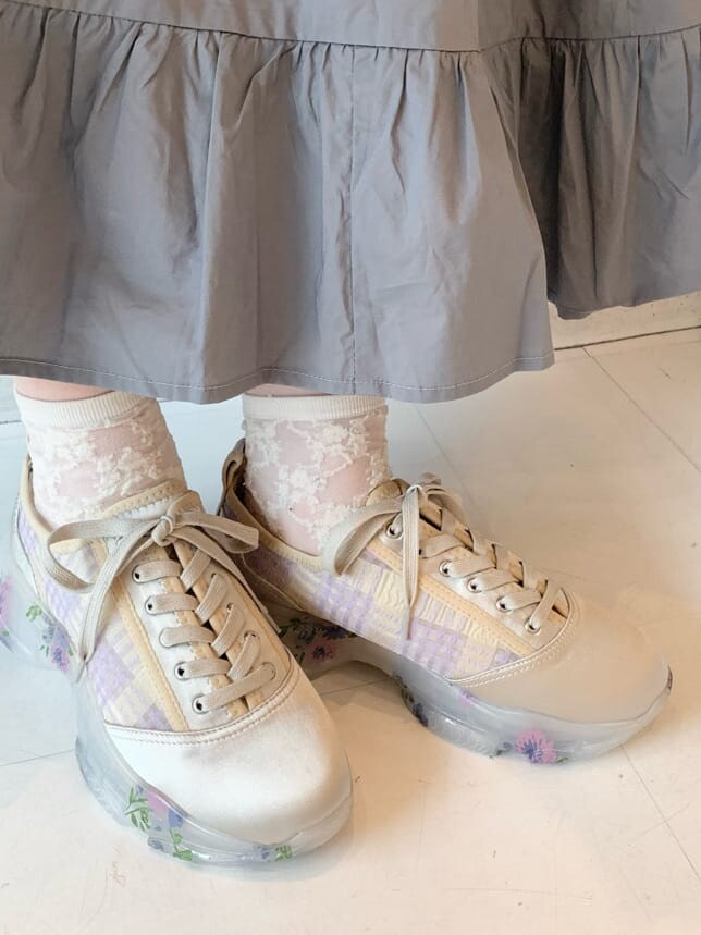 ベージュ系のカーディガン/ボレロ、ホワイト系のスニーカー、ホワイト系のショルダーバッグを着用したレディースの冬コーディネートの10枚目の写真