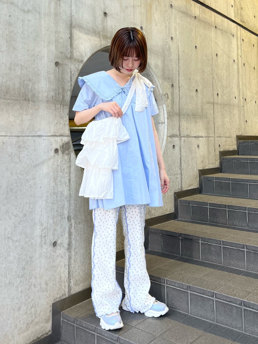 ホワイト系のトートバッグ、ブルー系のスニーカー、ブルー系のその他パンツを着用したレディースの春コーディネートの2枚目の写真