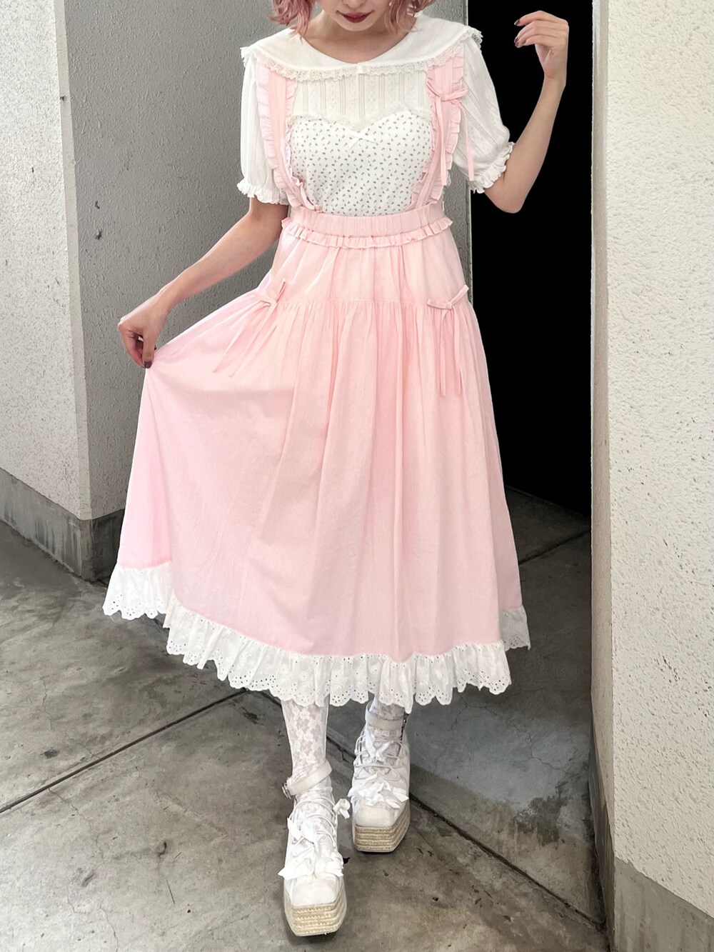 ホワイト系のTシャツ/カットソー、ピンク系のジャンパースカート、ホワイト系のサンダルを着用したレディースの夏コーディネートの4枚目の写真