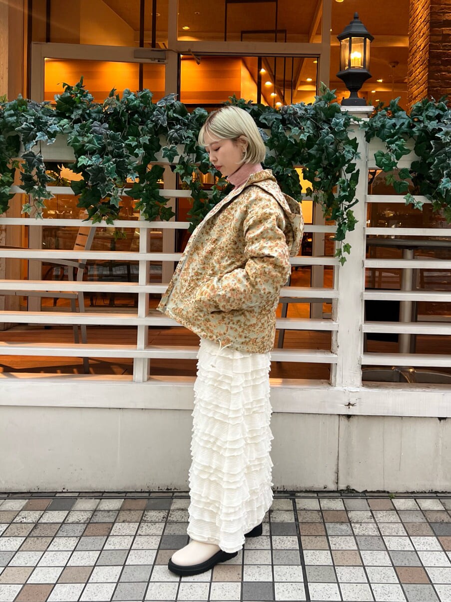 イエロー系のマウンテンパーカー、ホワイト系のブーツ、ホワイト系のワンピースを着用したレディースの秋コーディネートの4枚目の写真