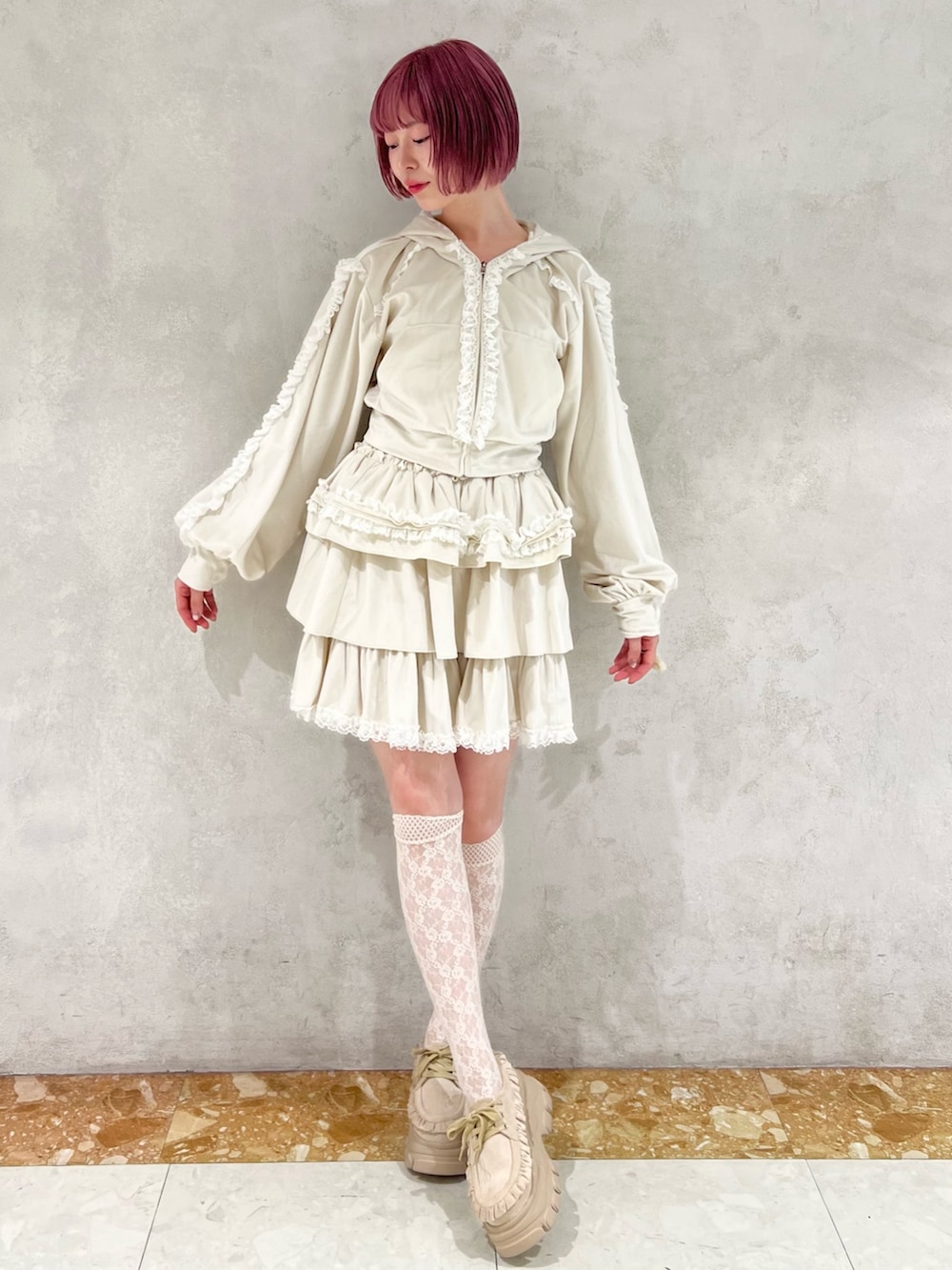 ホワイト系のスカート、ホワイト系のパーカー、ベージュ系のローファーを着用したレディースの秋コーディネートの4枚目の写真