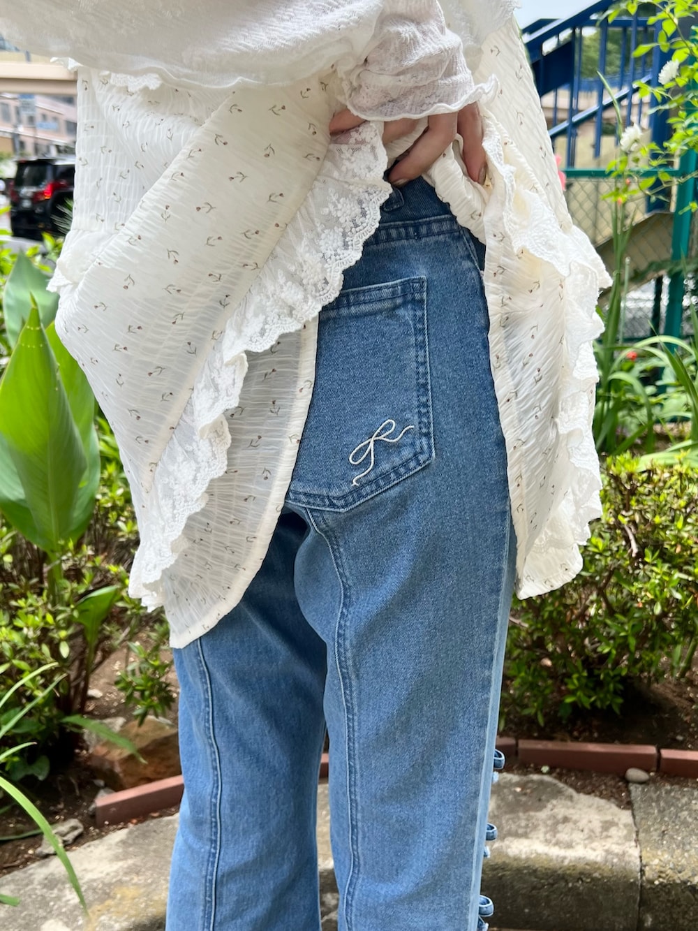 ホワイト系のチュニック、ホワイト系のTシャツ/カットソー、ブルー系のデニムパンツを着用したレディースの夏コーディネートの9枚目の写真