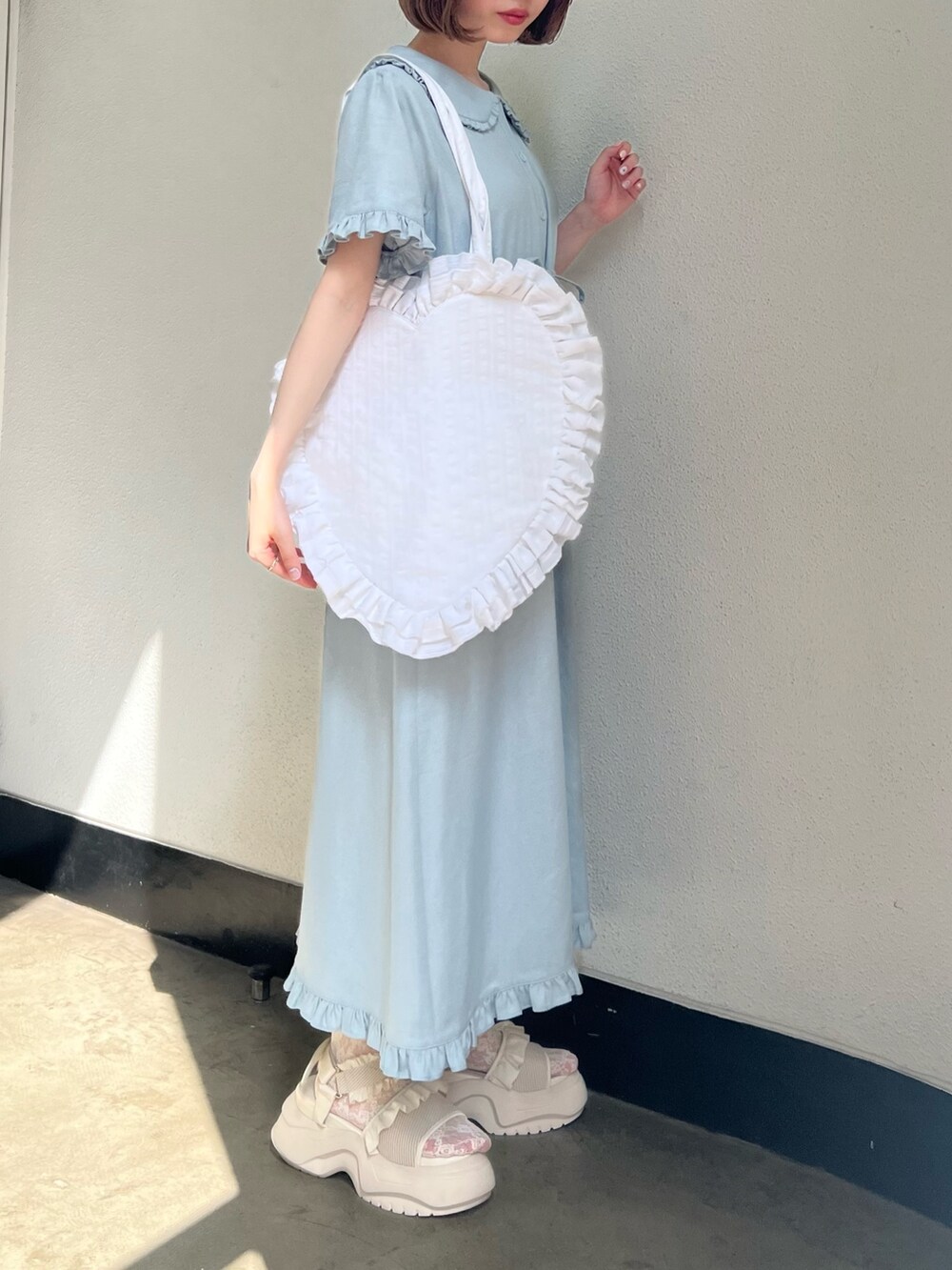 ブルー系のワンピース、ホワイト系のトートバッグ、ホワイト系のサンダルを着用したレディースの春コーディネートの3枚目の写真