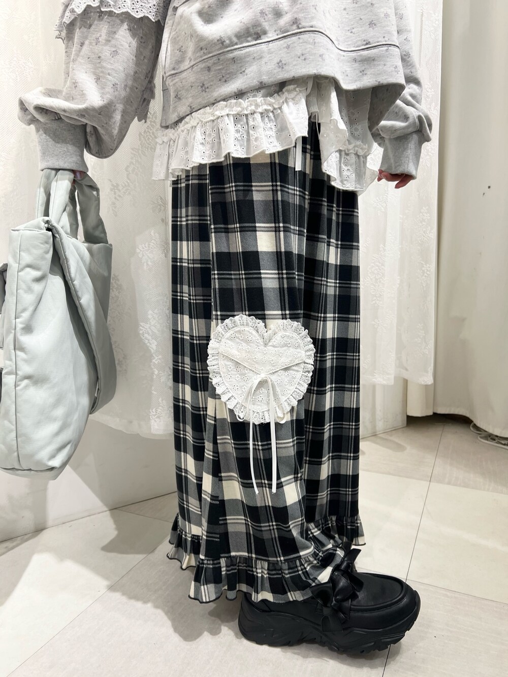 グレー系のスウェット、ベージュ系のスカート、ブラック系のスニーカーを着用したレディースの冬コーディネートの9枚目の写真