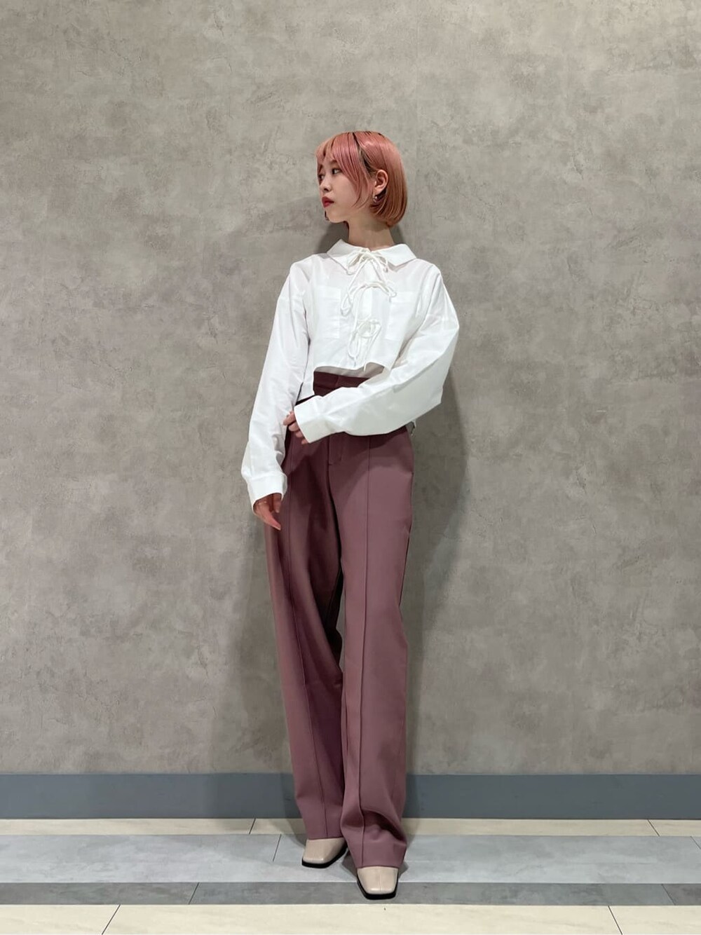 ホワイト系のシャツ/ブラウス、ピンク系のスラックス、ベージュ系のブーツを着用したレディースの秋コーディネートの4枚目の写真