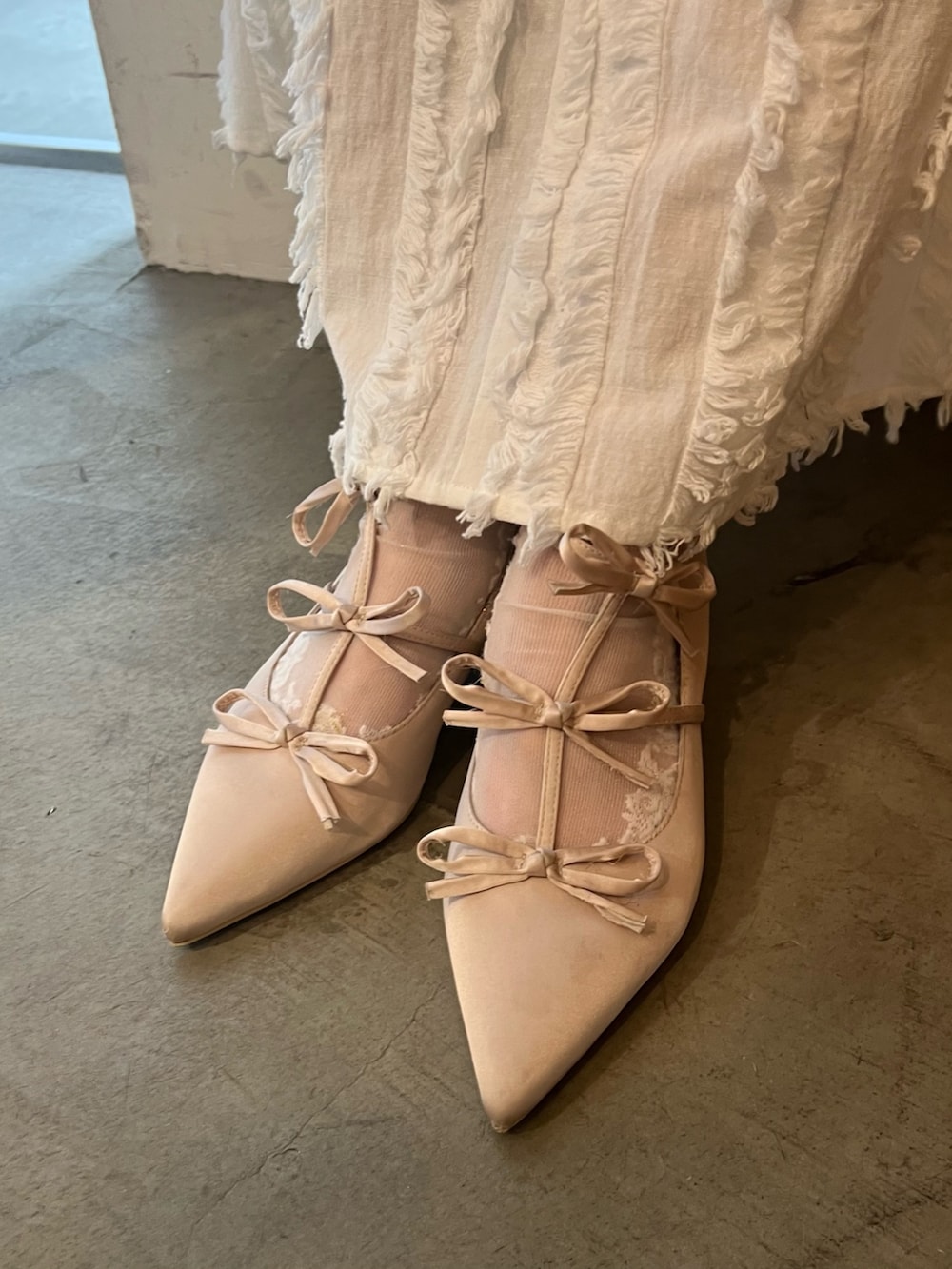 ホワイト系のワンピース、ベージュ系のTシャツ/カットソー、ベージュ系のパンプスを着用したレディースの春コーディネートの6枚目の写真