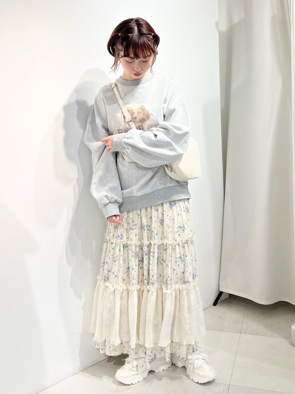 ホワイト系のショルダーバッグ、ホワイト系のスニーカー、ブルー系のスカートを着用したレディースの冬コーディネートの5枚目の写真