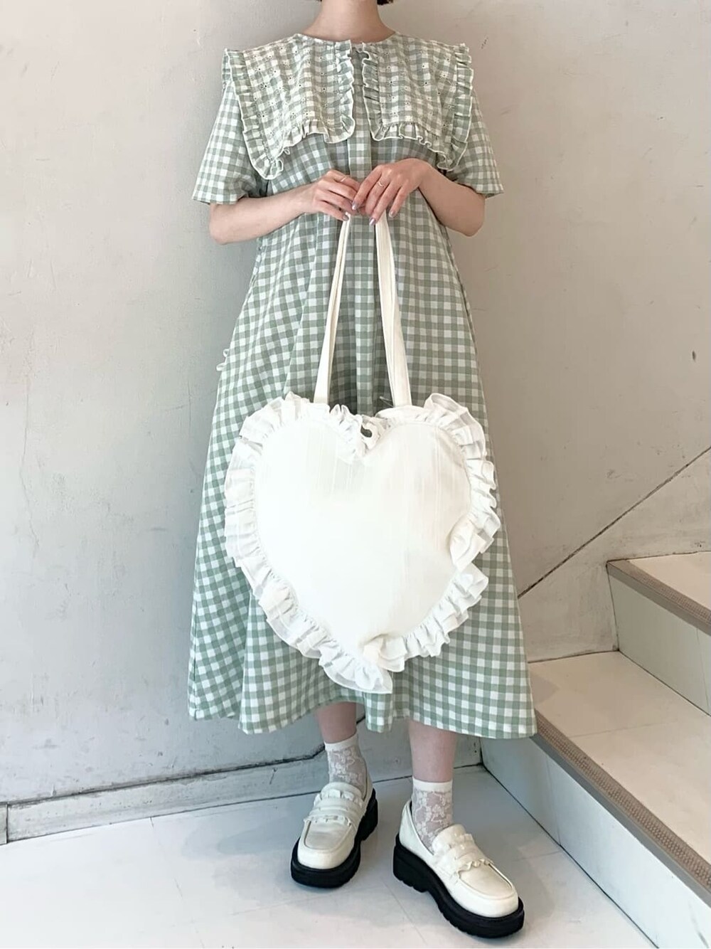 ホワイト系のローファー、グリーン系のワンピース、ホワイト系のトートバッグを着用したレディースの春コーディネートの3枚目の写真