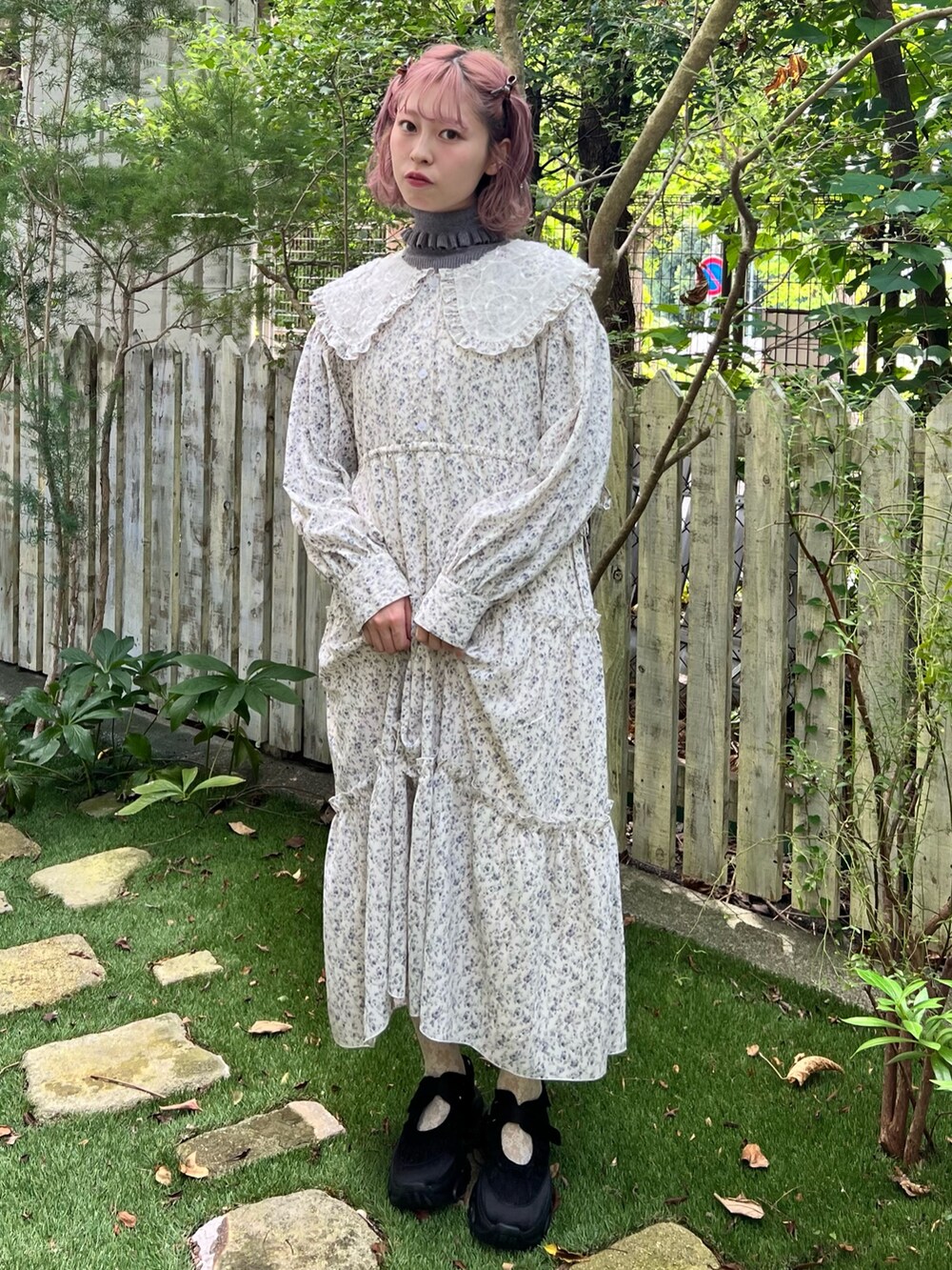 ホワイト系のワンピース、グレー系のニット/セーター、ブラック系のスニーカーを着用したレディースの秋コーディネートの4枚目の写真