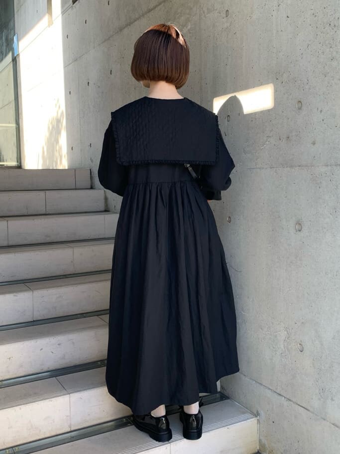 ブラック系のパンプス、ブラック系のワンピース、ブラック系のショルダーバッグを着用したレディースの冬コーディネートの4枚目の写真