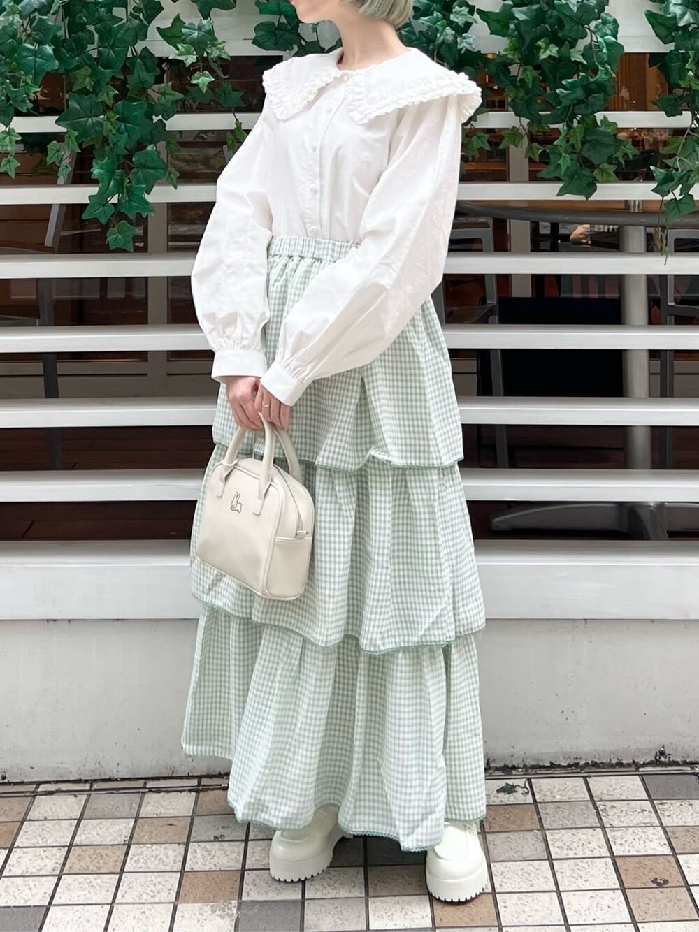ホワイト系のシャツ/ブラウス、グリーン系のスカート、ホワイト系のボストンバッグを着用したレディースの秋コーディネートの3枚目の写真