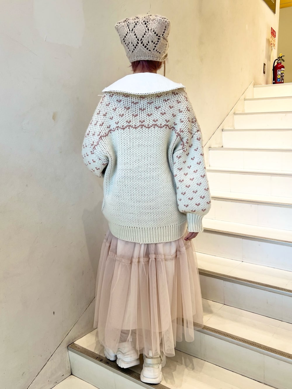 ピンク系のカーディガン/ボレロ、ホワイト系のシャツ/ブラウス、ピンク系のワンピースを着用したレディースの冬コーディネートの3枚目の写真