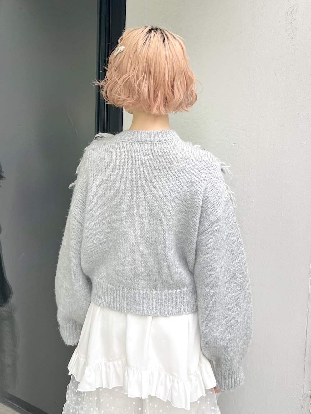 グレー系のニット/セーター、ホワイト系のショルダーバッグ、ホワイト系のスカートを着用したレディースの秋コーディネートの10枚目の写真