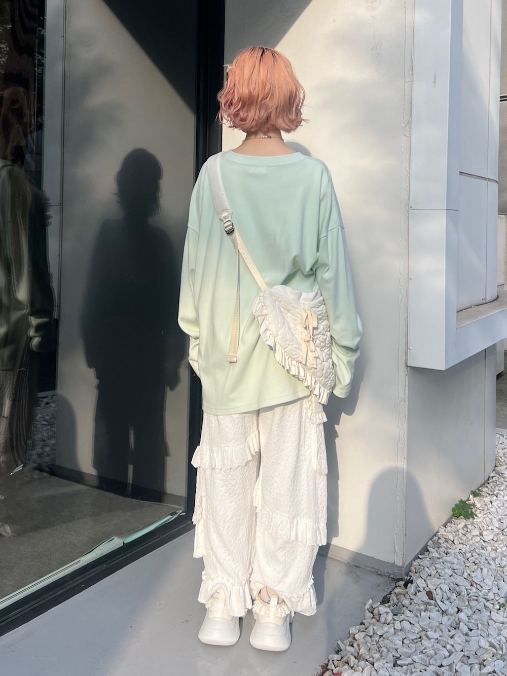 グリーン系のTシャツ/カットソー、ホワイト系のショルダーバッグ、ホワイト系のカーゴパンツを着用したレディースの夏コーディネートの4枚目の写真