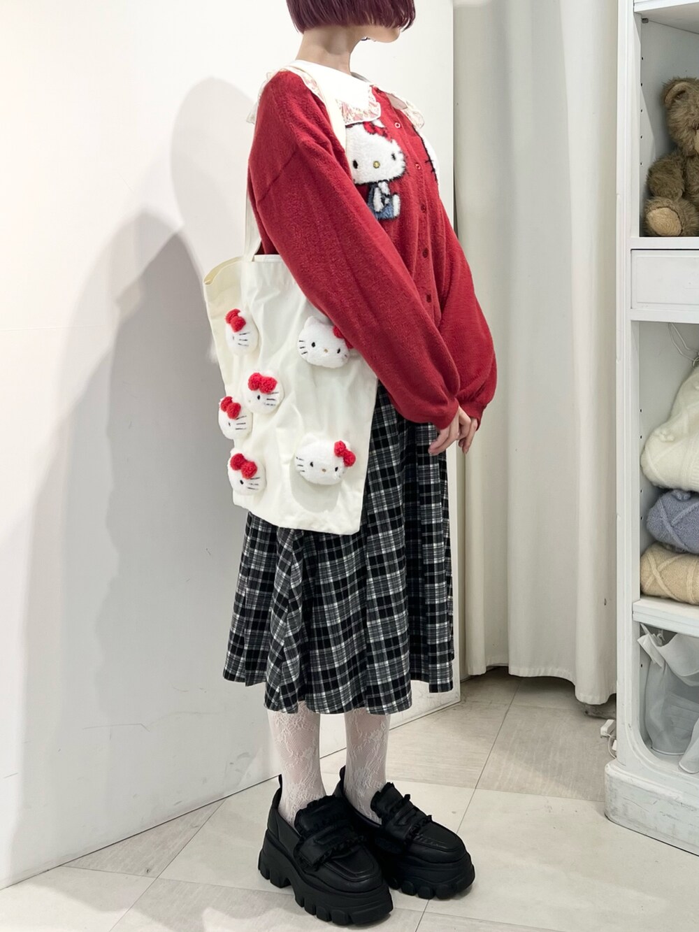 レッド系のカーディガン/ボレロ、ゴールド系のシャツ/ブラウス、ブラック系のスカートを着用したレディースの秋コーディネートの6枚目の写真