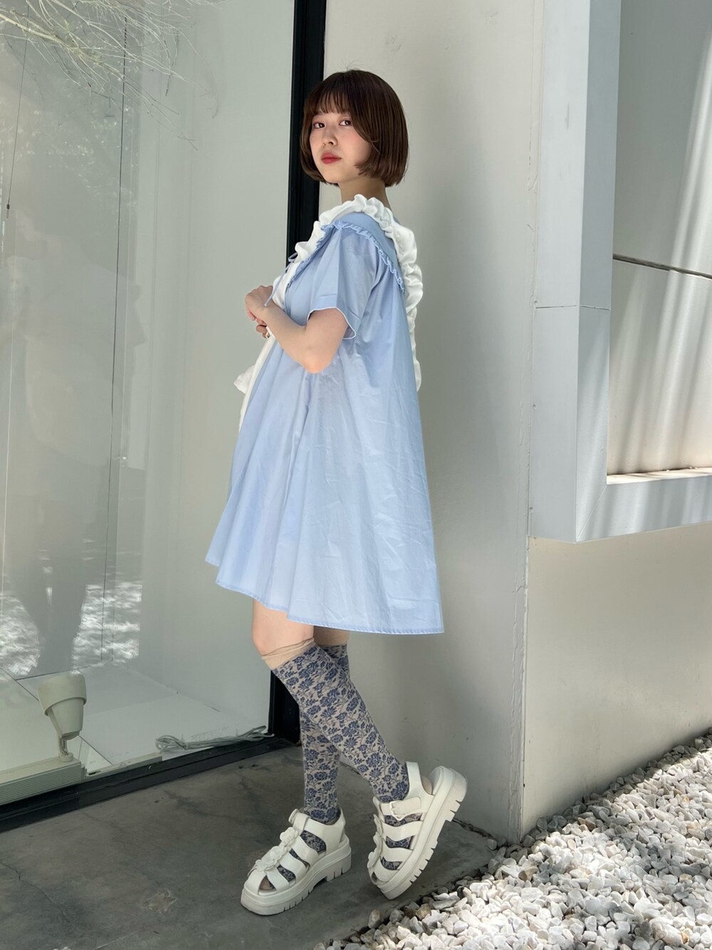 ブルー系のワンピース、ホワイト系のサンダル、ホワイト系のショルダーバッグを着用したレディースの春コーディネートの3枚目の写真