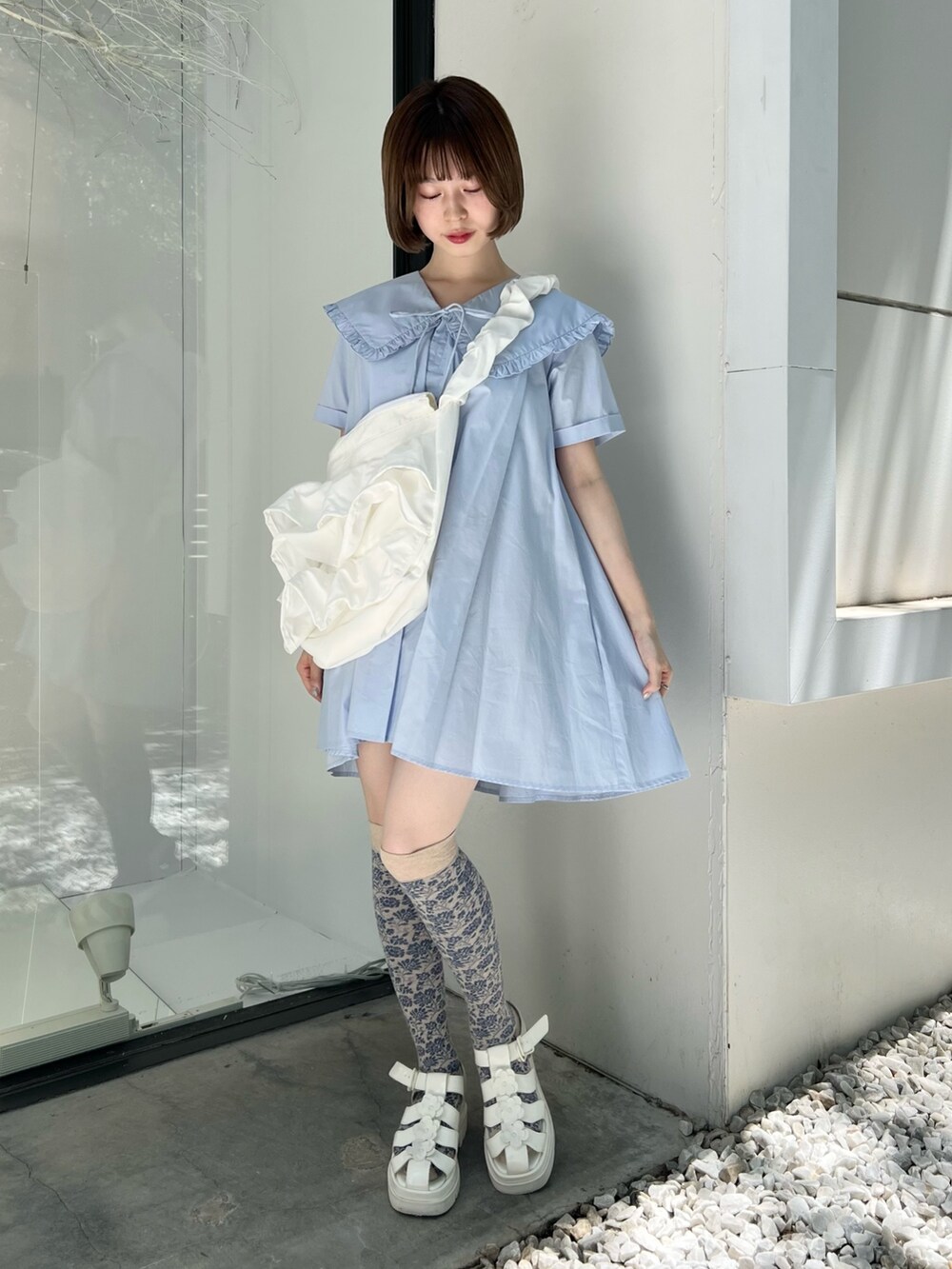 ブルー系のワンピース、ホワイト系のサンダル、ホワイト系のショルダーバッグを着用したレディースの春コーディネートの2枚目の写真