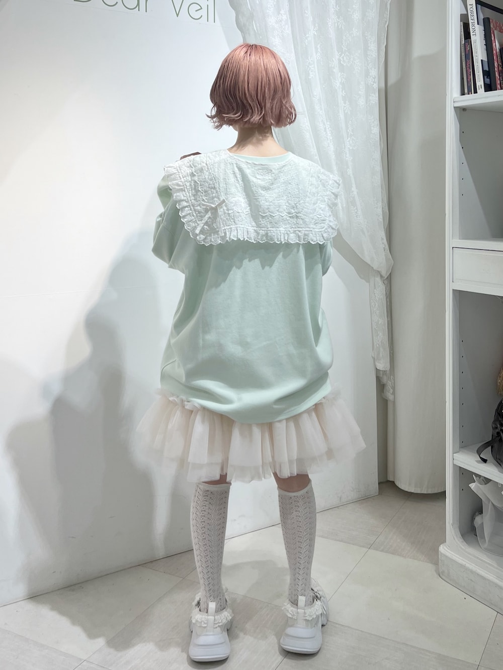 グリーン系のTシャツ/カットソー、ピンク系のスカート、ホワイト系のスニーカーを着用したレディースの夏コーディネートの4枚目の写真