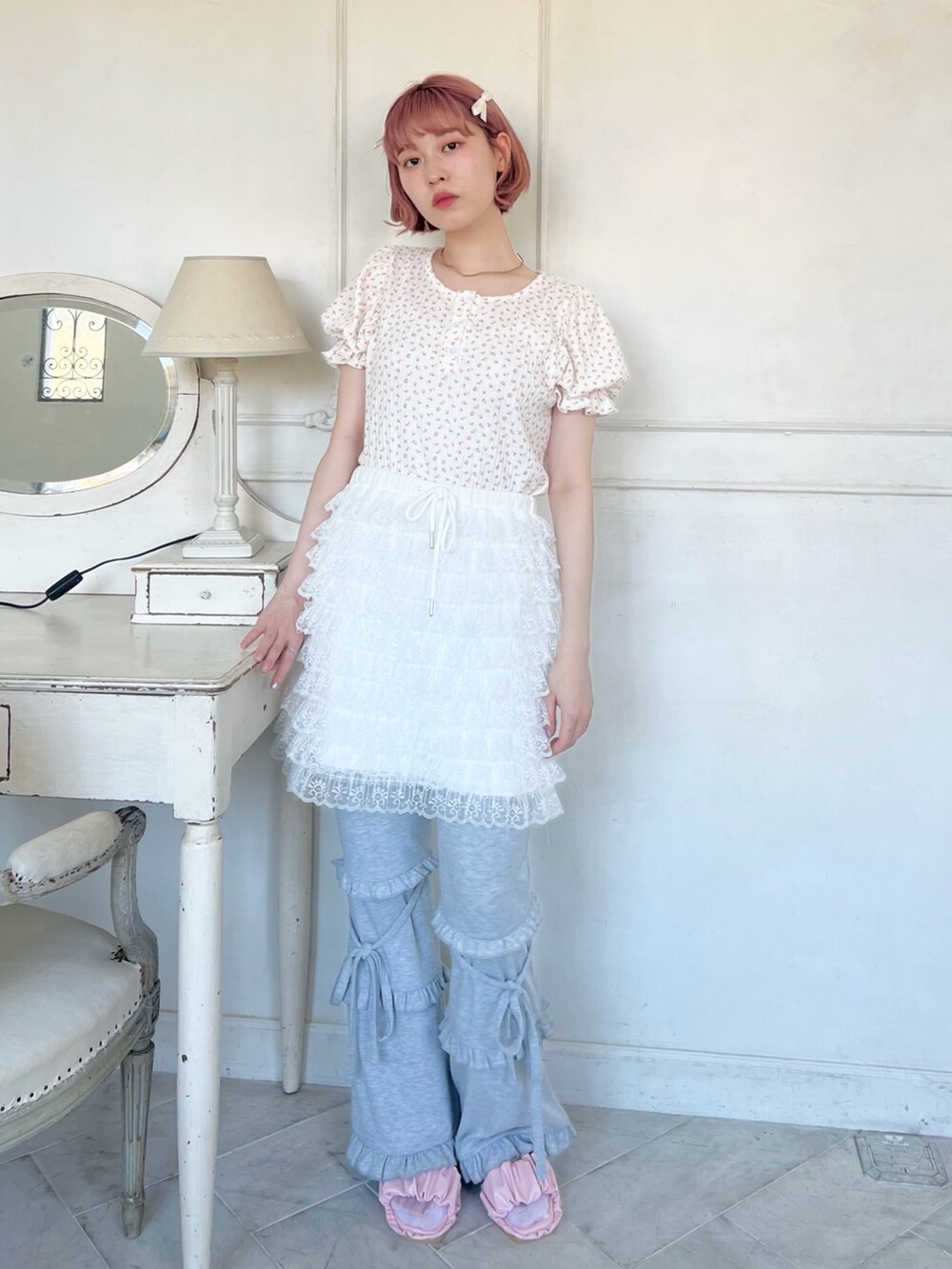 ピンク系のサンダル、グレー系のスウェットパンツ、ホワイト系のスカートを着用したレディースの春コーディネートの2枚目の写真