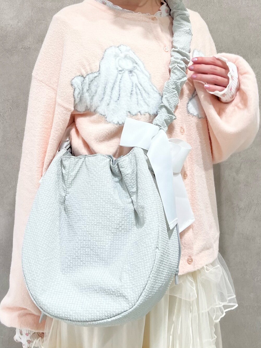 ピンク系のTシャツ/カットソー、ホワイト系のスカート、ホワイト系のスニーカーを着用したレディースの秋コーディネートの9枚目の写真