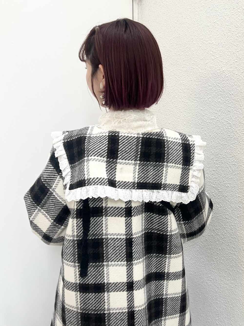 ブラック系のチェスターコート、ホワイト系のニット/セーター、ブラック系のハンドバッグを着用したレディースの秋コーディネートの6枚目の写真