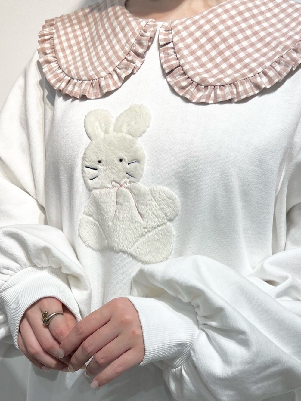 ホワイト系のショルダーバッグ、ピンク系のワンピース、ホワイト系のスウェットを着用したレディースの冬コーディネートの9枚目の写真