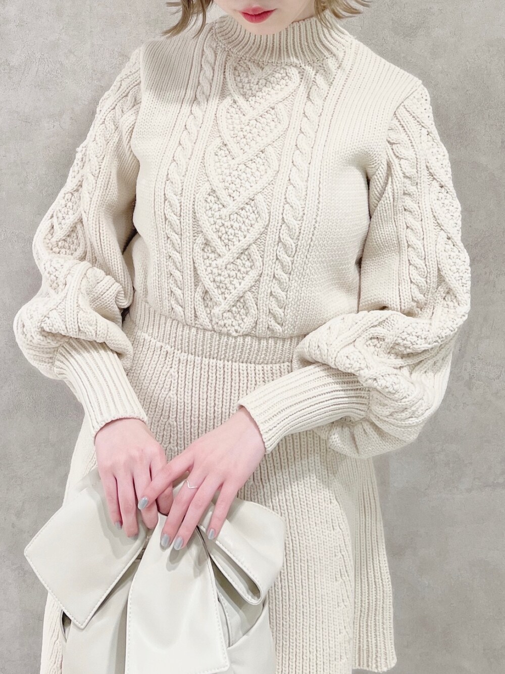 ホワイト系のワンピース、ベージュ系のブーツ、ホワイト系のショルダーバッグを着用したレディースの冬コーディネートの6枚目の写真