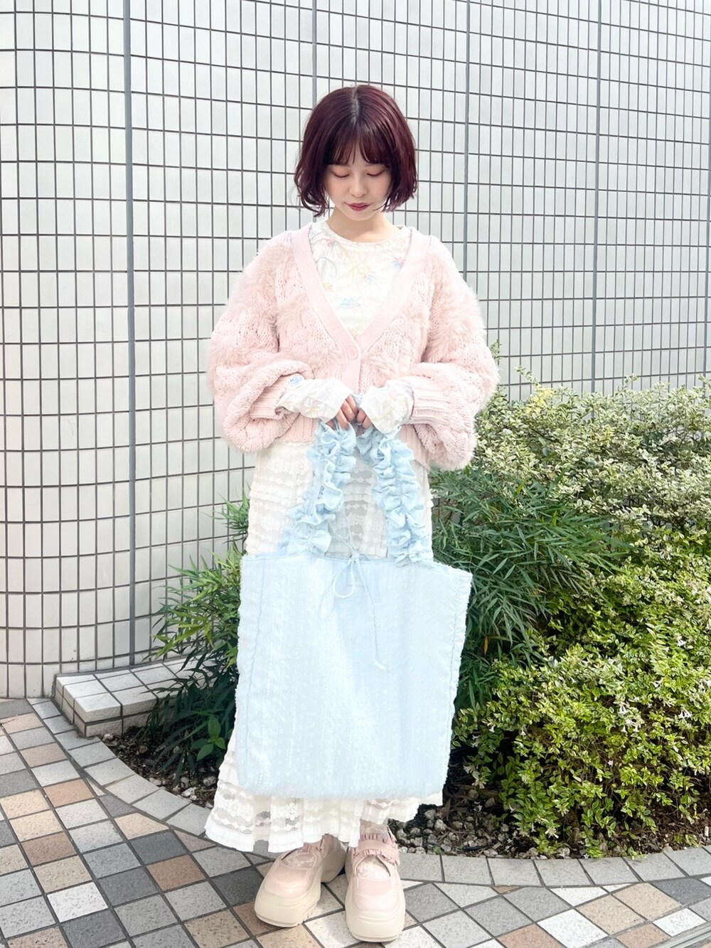 ホワイト系のスカート、ホワイト系のTシャツ/カットソー、ピンク系のスニーカーを着用したレディースの秋コーディネートの2枚目の写真