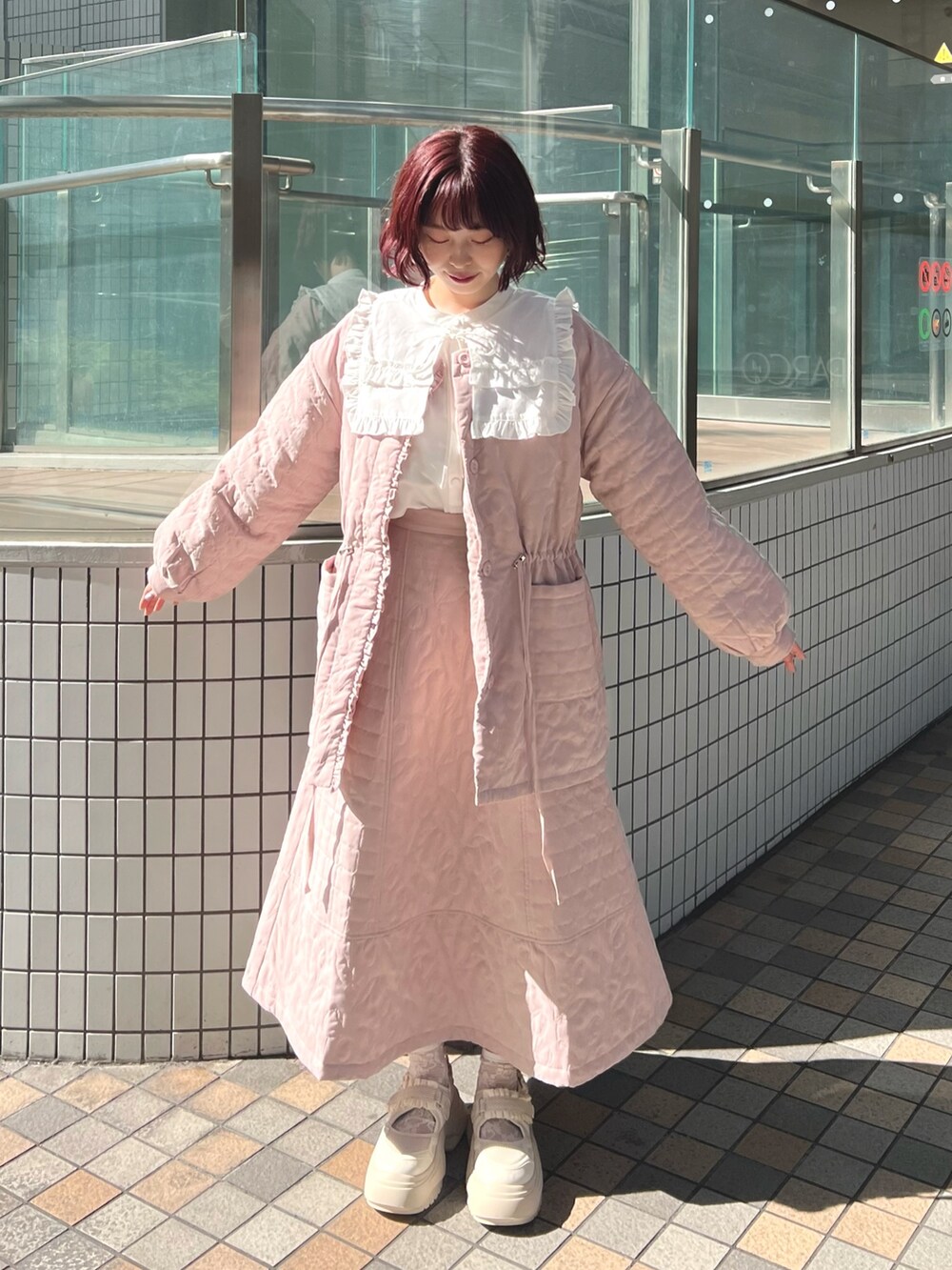 ピンク系のスカート、ピンク系のブルゾン、ホワイト系のシャツ/ブラウスを着用したレディースの秋コーディネートの2枚目の写真
