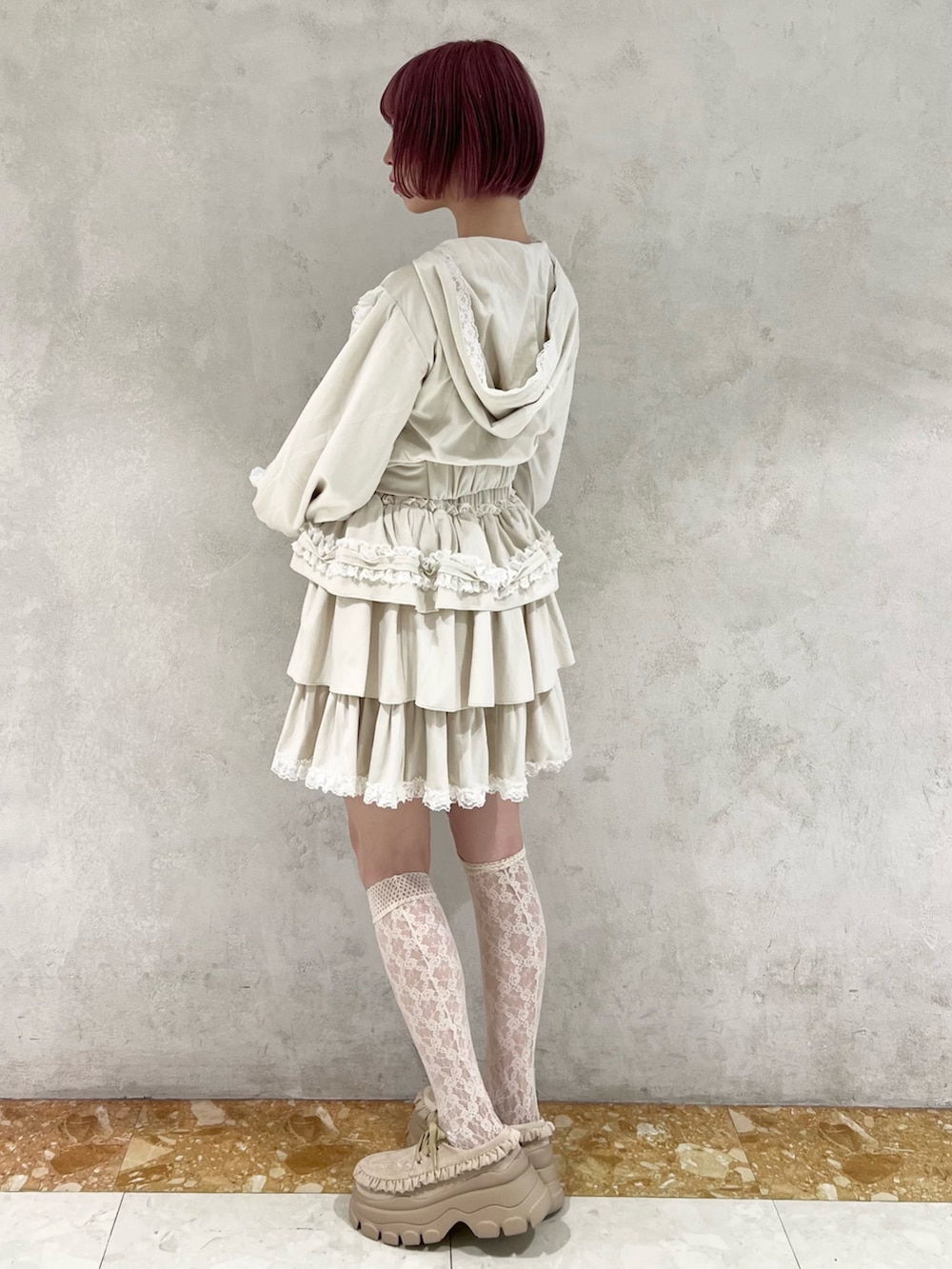 ホワイト系のスカート、ホワイト系のパーカー、ベージュ系のローファーを着用したレディースの秋コーディネートの5枚目の写真