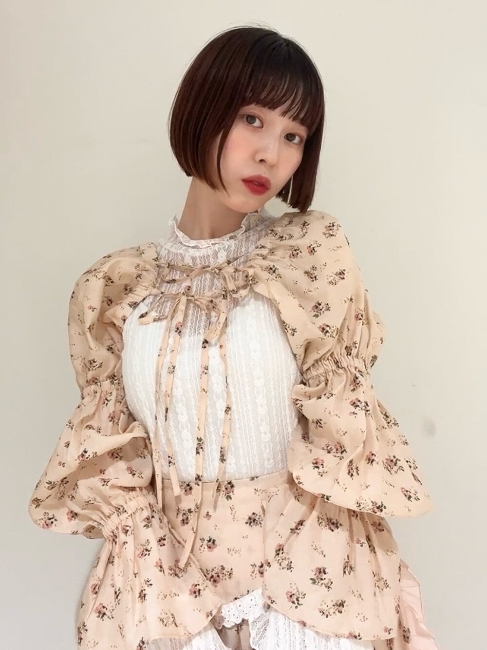 ピンク系のスカート、ピンク系のカーディガン/ボレロ、ホワイト系のパンプスを着用したレディースの春コーディネートの6枚目の写真