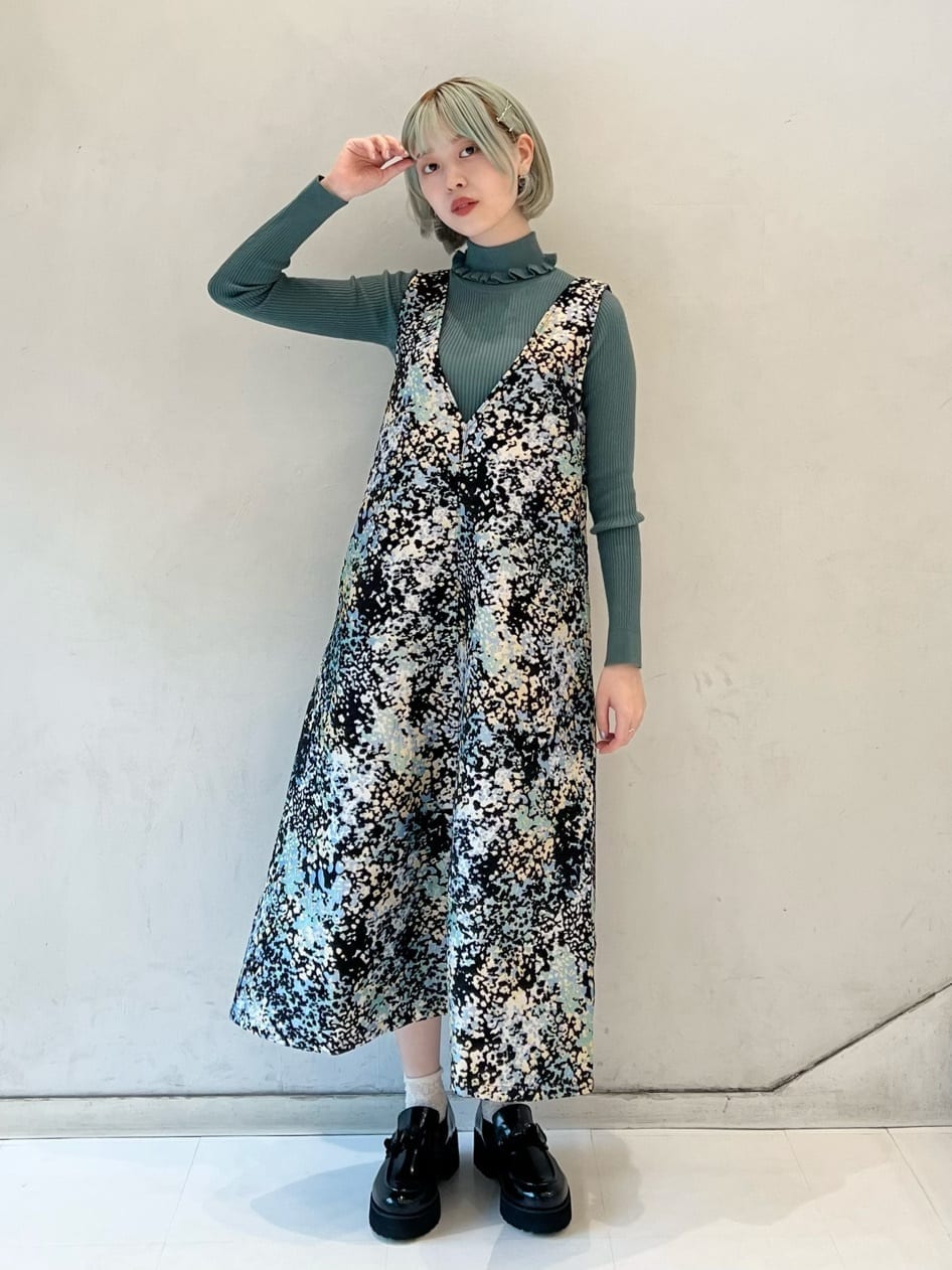 グリーン系のニット/セーター、ブラック系のワンピース、ブラック系のローファーを着用したレディースの秋コーディネートの2枚目の写真