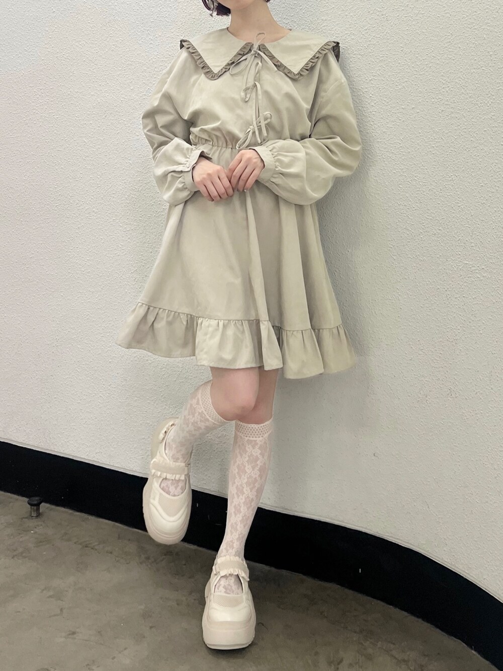 ベージュ系のワンピース、ホワイト系のスニーカーを着用したレディースの秋コーディネートの3枚目の写真