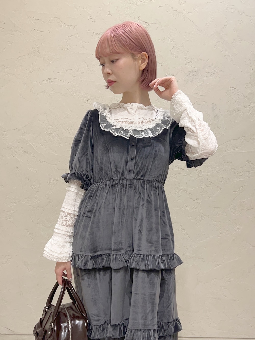 グレー系のワンピース、ブラウン系のハンドバッグ、ホワイト系のスニーカーを着用したレディースの夏コーディネートの5枚目の写真