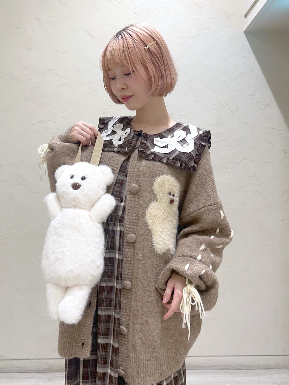 ホワイト系のハンドバッグ、ブラウン系のカーディガン/ボレロ、ブラウン系のワンピースを着用したレディースの秋コーディネートの6枚目の写真