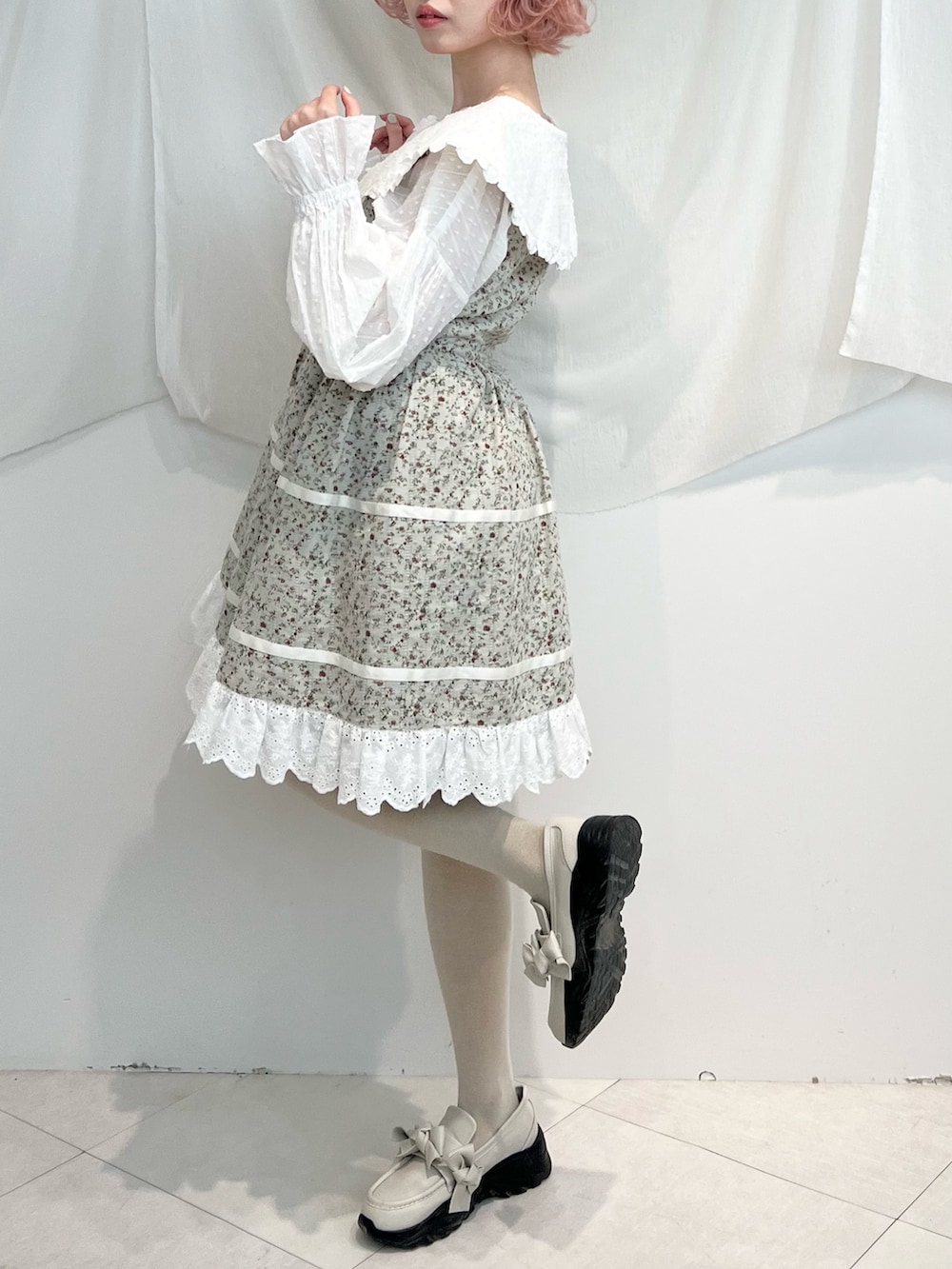 ホワイト系のシャツ/ブラウス、グリーン系のワンピース、ホワイト系のスニーカーを着用したレディースの冬コーディネートの6枚目の写真