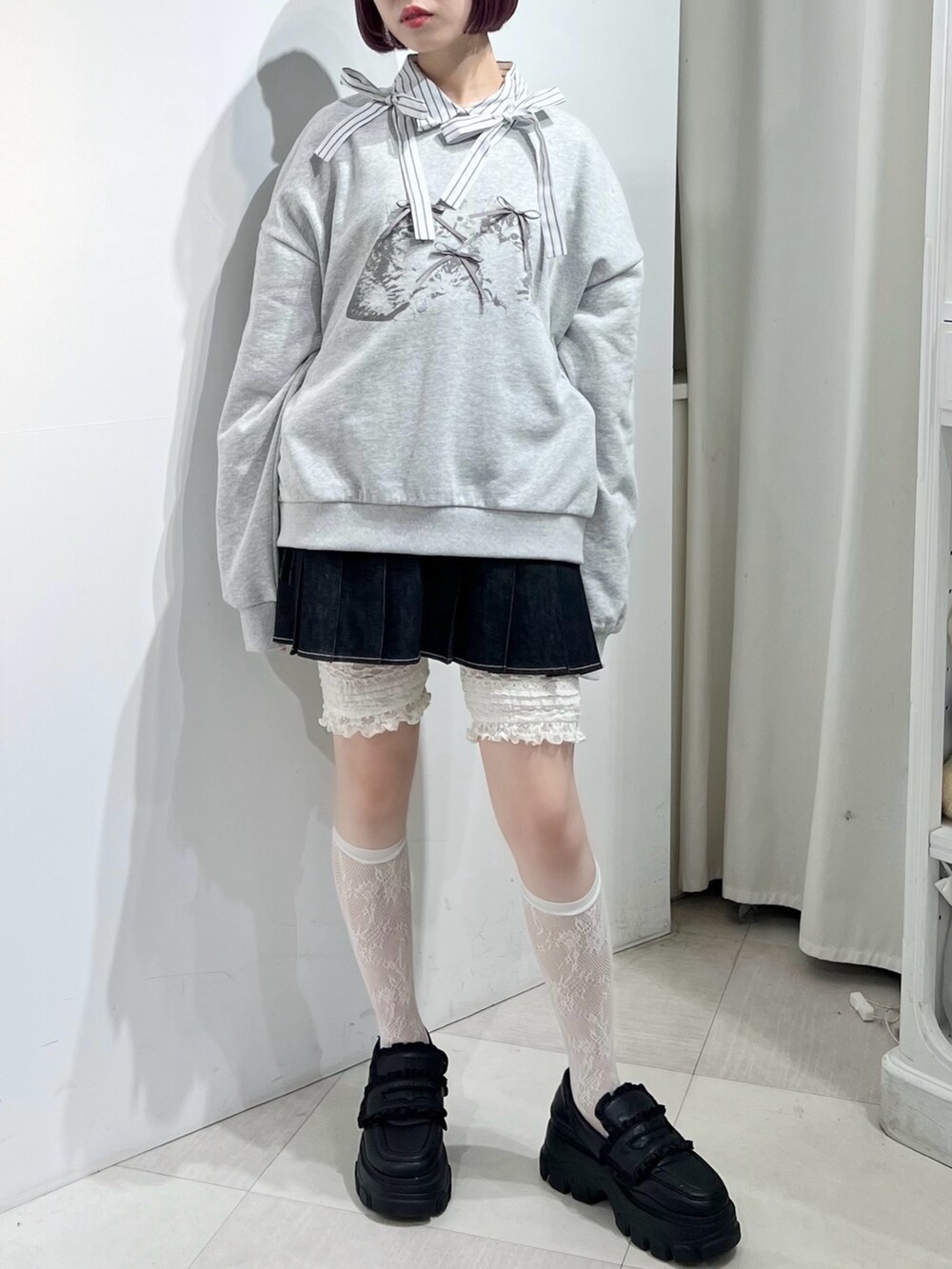 グレー系のスウェット、ブラック系のスカート、ブラック系のローファーを着用したレディースの秋コーディネートの3枚目の写真