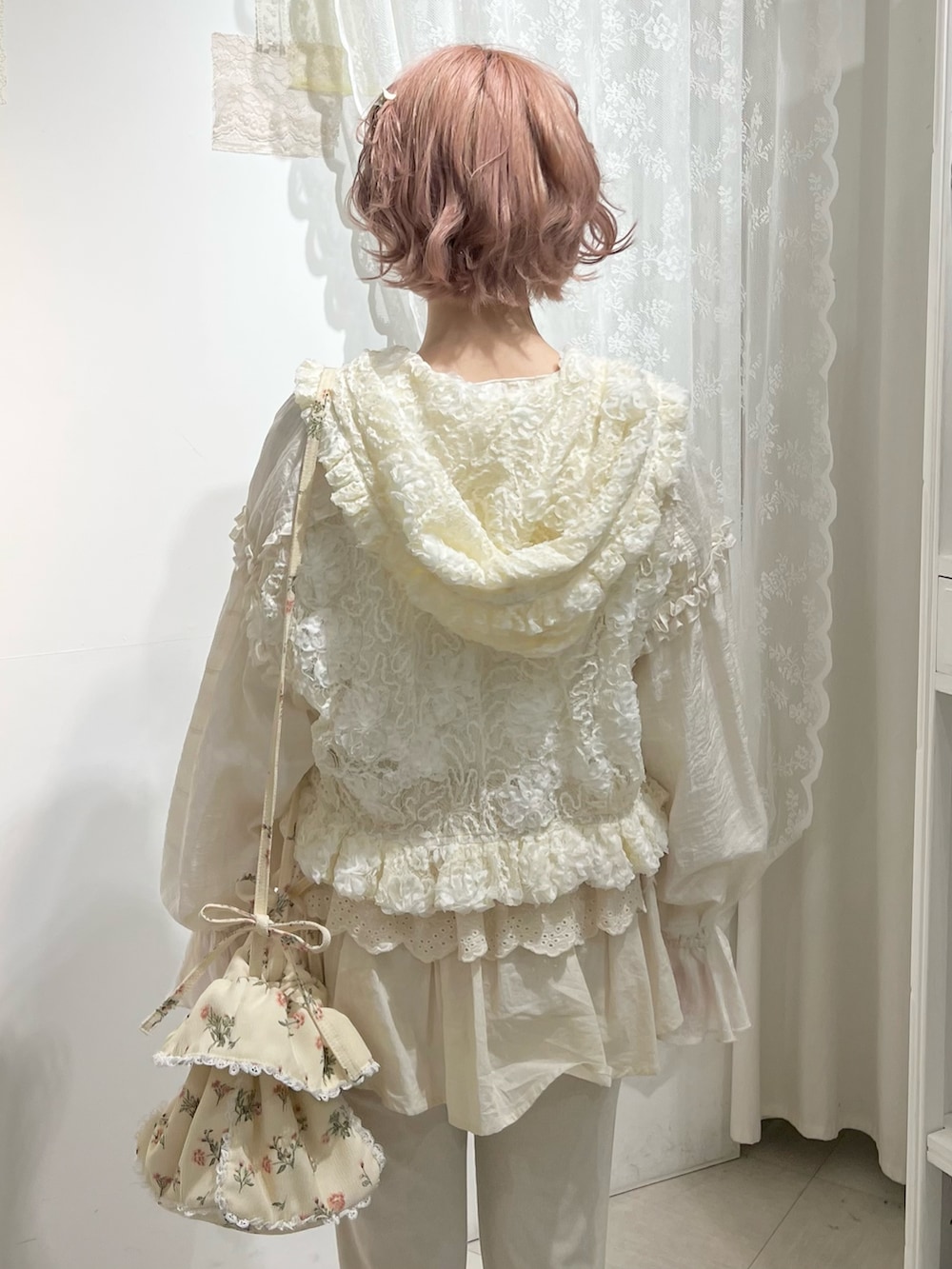 ホワイト系のスニーカー、ホワイト系のスウェットパンツ、ホワイト系のショルダーバッグを着用したレディースの冬コーディネートの9枚目の写真