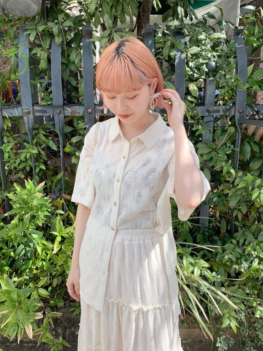 グリーン系のショルダーバッグ、ホワイト系のスカート、グリーン系のパンプスを着用したレディースの春コーディネートの3枚目の写真