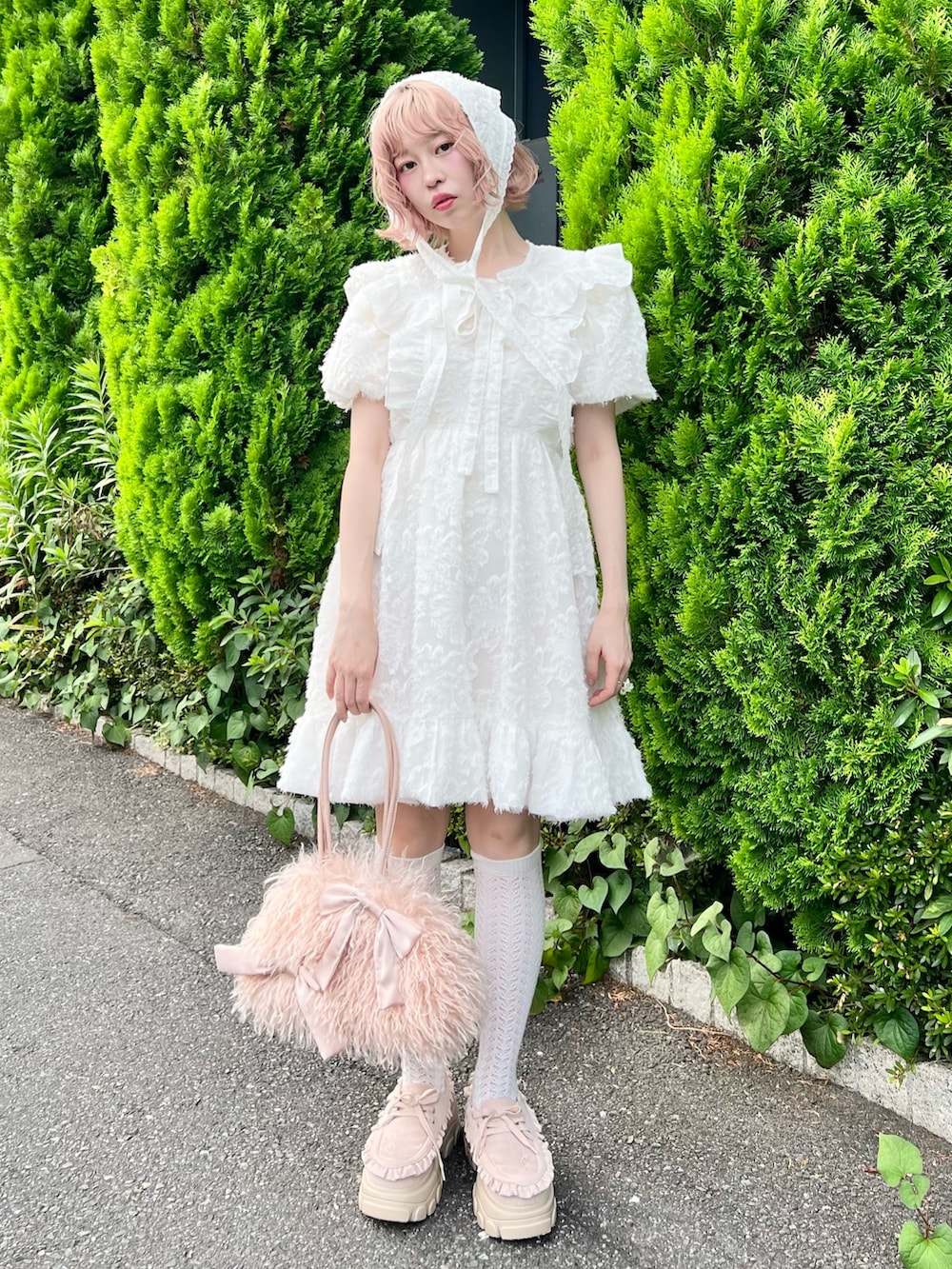 ホワイト系のワンピース、ピンク系のボストンバッグ、ピンク系のローファーを着用したレディースの夏コーディネートの3枚目の写真