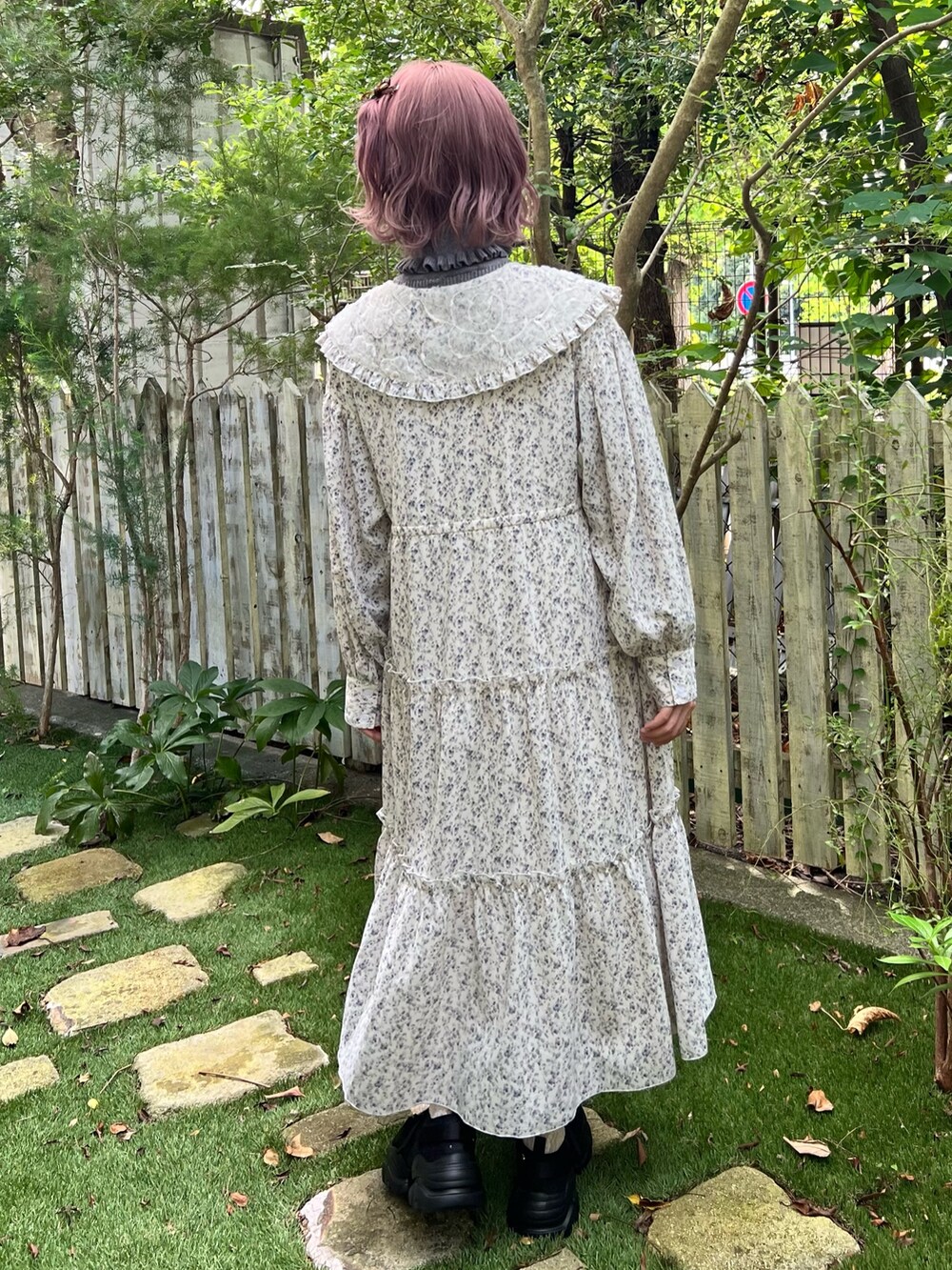 ホワイト系のワンピース、グレー系のニット/セーター、ブラック系のスニーカーを着用したレディースの秋コーディネートの3枚目の写真