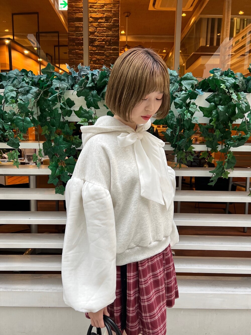 ブラック系のローファー、ホワイト系のパーカー、ブラック系のボストンバッグを着用したレディースの冬コーディネートの6枚目の写真