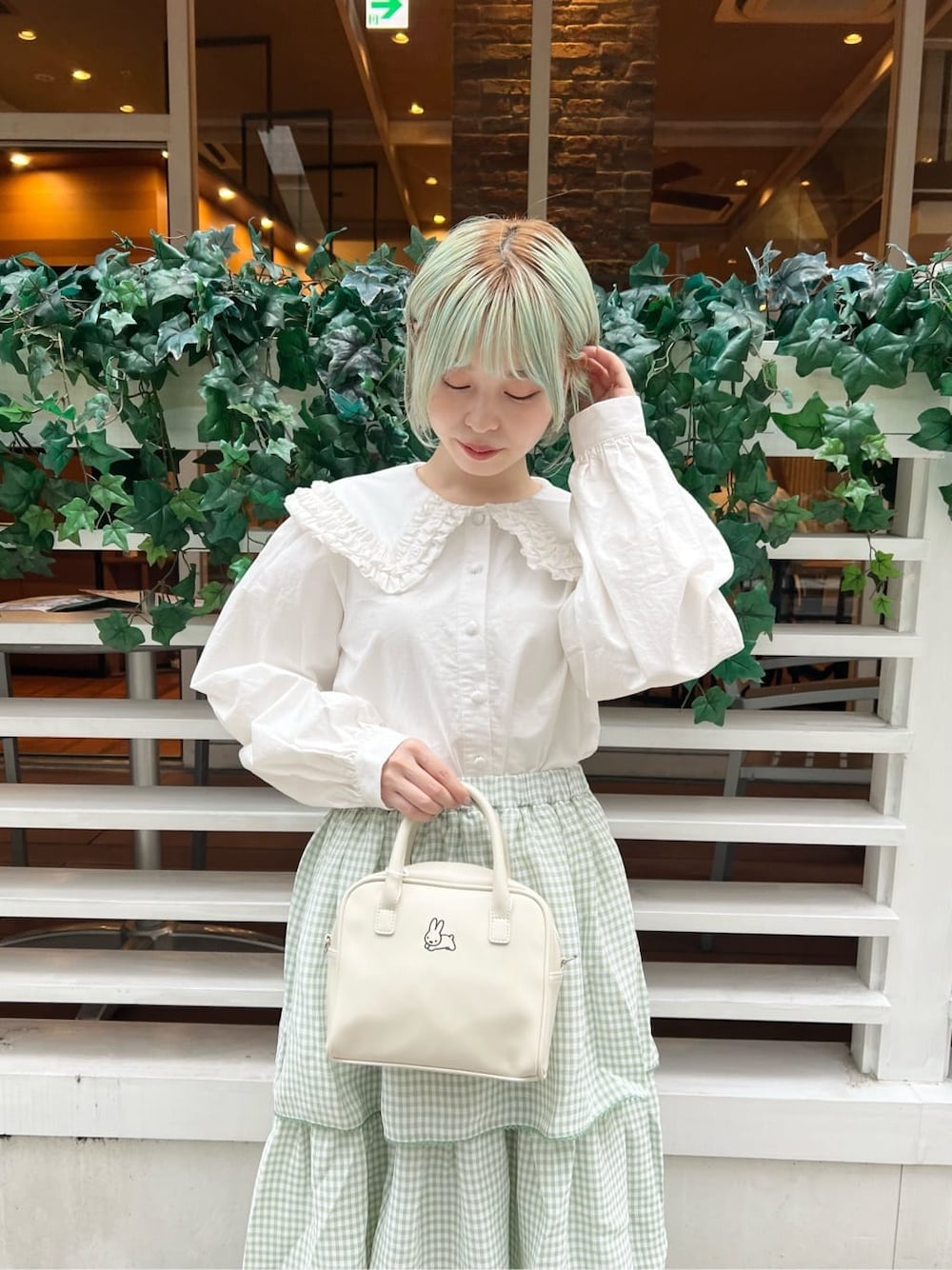 ホワイト系のシャツ/ブラウス、グリーン系のスカート、ホワイト系のボストンバッグを着用したレディースの秋コーディネートの5枚目の写真