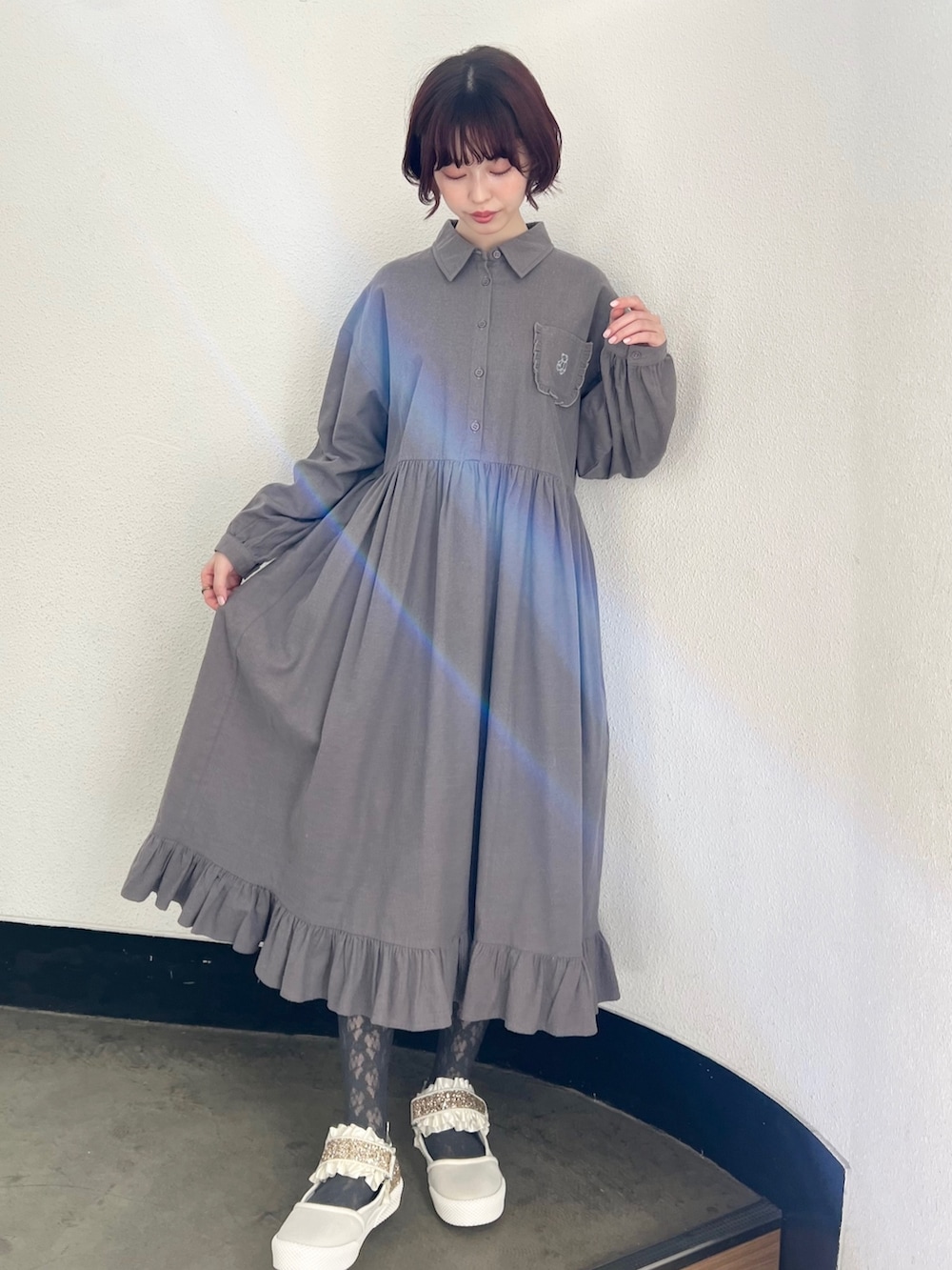 ブラック系のブルゾン、グレー系のワンピース、ホワイト系のスニーカーを着用したレディースの冬コーディネートの4枚目の写真