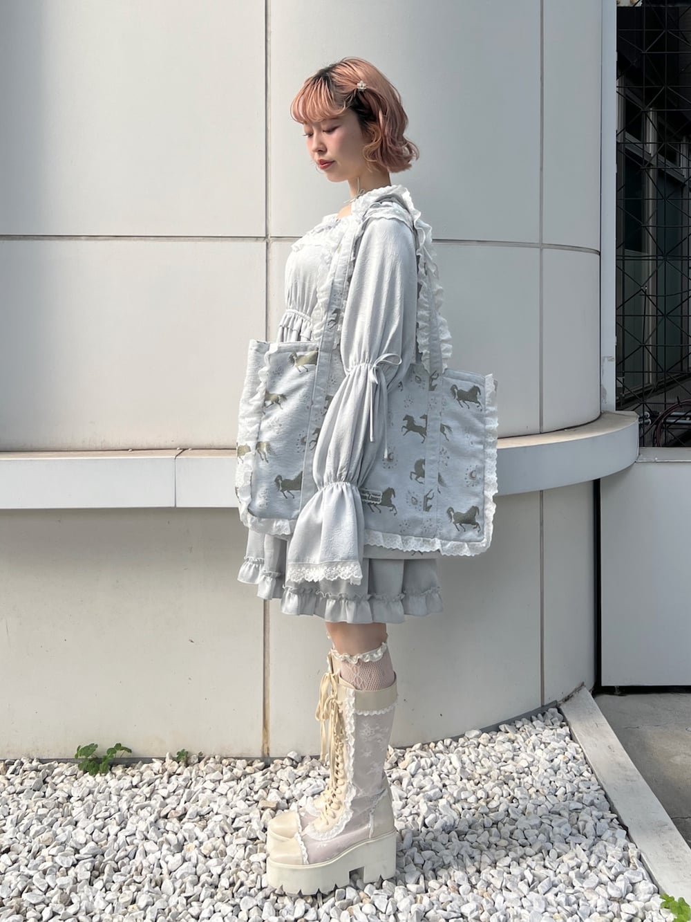 ブルー系のワンピース、ブルー系のトートバッグ、ホワイト系のブーツを着用したレディースの夏コーディネートの2枚目の写真