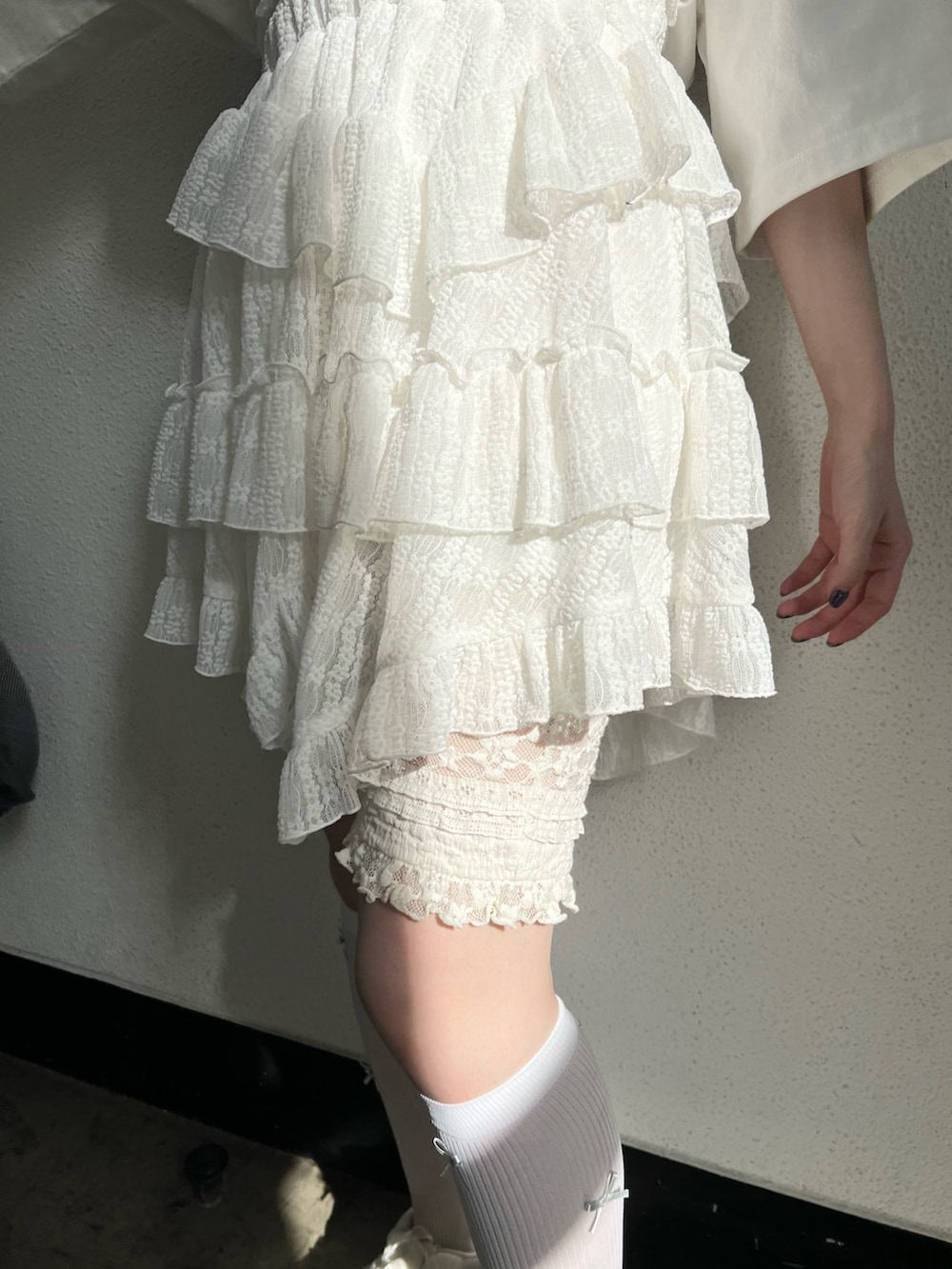 ホワイト系のTシャツ/カットソー、ホワイト系のスカート、ホワイト系のスニーカーを着用したレディースの春コーディネートの9枚目の写真